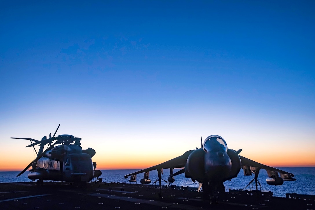 A CH-53E Super Stallion helicopter, left, and an AV-8B Harrier sit on the flight deck of the amphibious assault ship USS Bonhomme Richard in the Coral Sea, July 29, 2017. The helicopter is assigned to Marine Medium Tiltrotor Squadron 265 Reinforced. The Harrier is assigned to Marine Attack Squadron 311. Navy photo by Petty Officer 3rd Class William Sykes