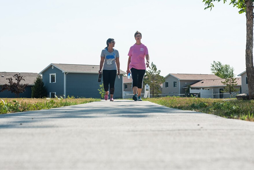 From left, Sheena Swanner, 5th Medical Operations Squadron health promotion dietician, and Lori Halvorson, 5 MDOS health promotion coordinator, walk through Frog Park at Minot Air Force Base, N.D., July 23, 2017. The Minot Monday Community Walks last from 45 minutes to an hour and are used to promote health and wellness in the base community. (U.S. Air Force photo by Airman 1st Class Jonathan McElderry)
