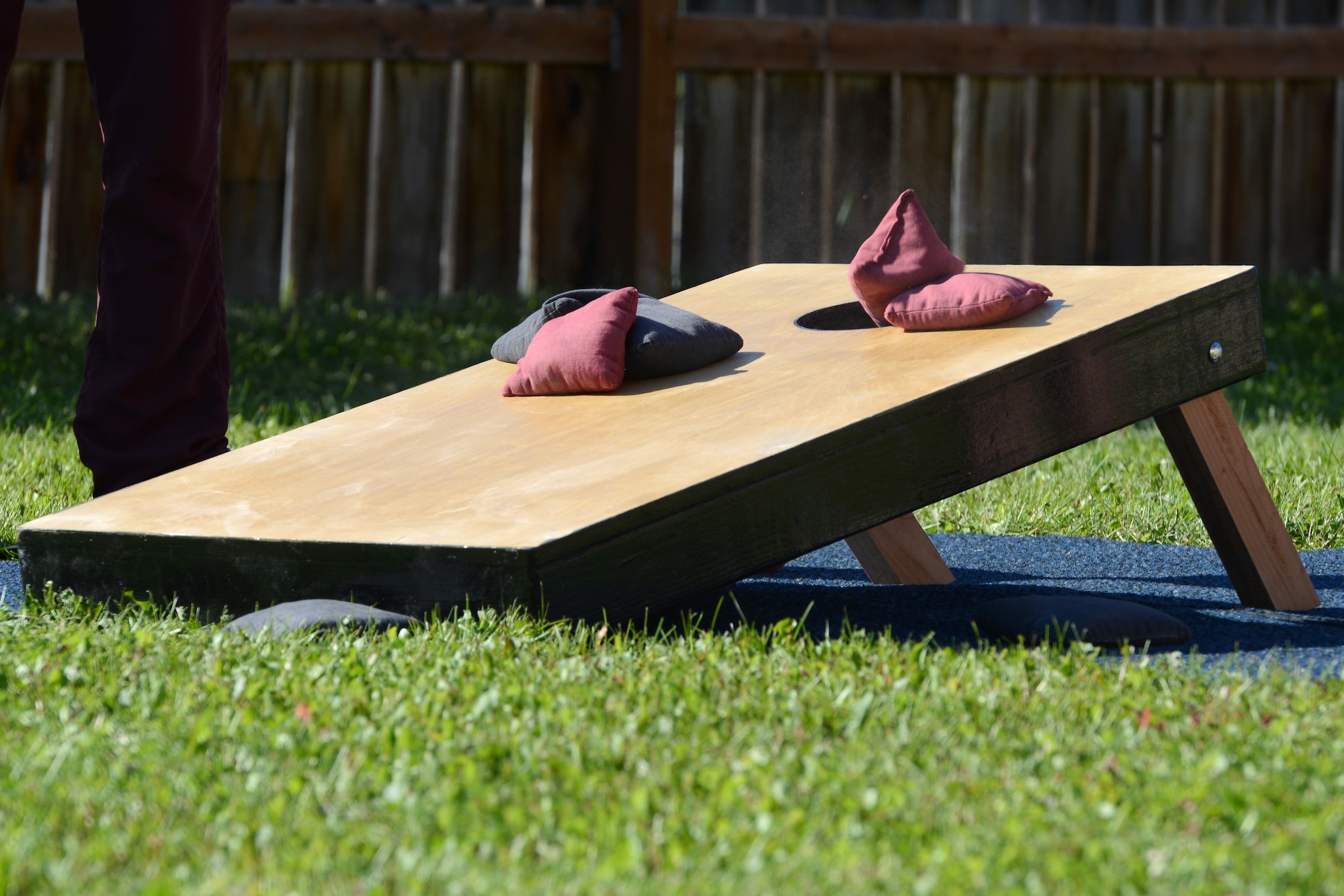 A competitor throws a beanbag into the hole on the board scoring three points at a cornhole tournament at the Warrior Zone at Joint Base Elmendorf-Richardson, Alaska, July 22, 2017. The tournament had a total of 18 teams and played a double-elimination bracket, meaning a team was eliminated if they lost twice. 