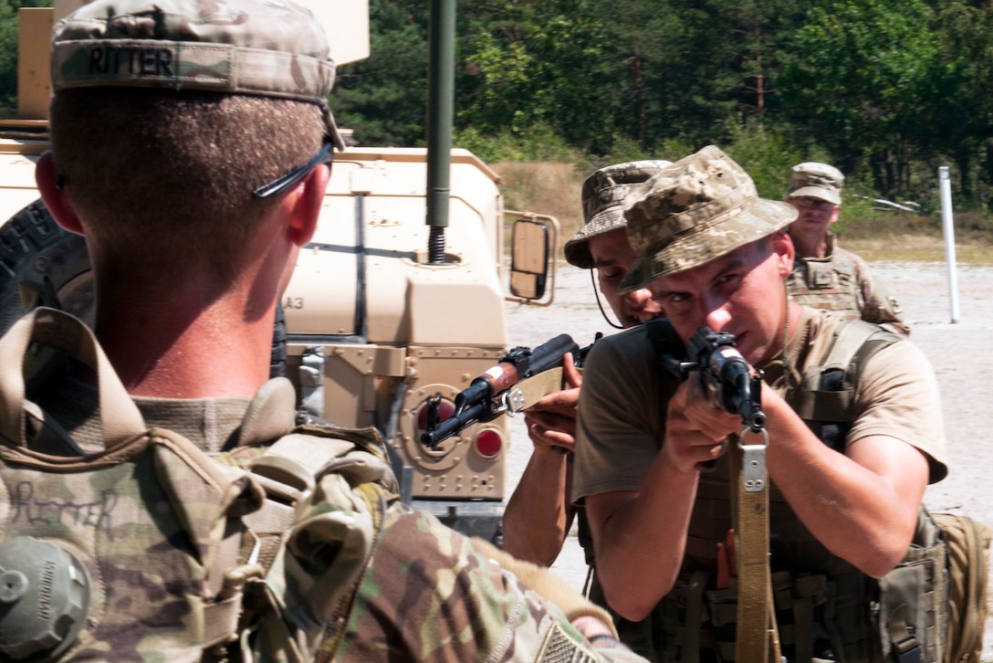 U.S. Army Spc. Wyatt Ritter, left, assigned to 1st Battalion, 279th Infantry Regiment, 45th Infantry Brigade Combat Team, coaches Ukrainian soldiers assigned to the 95th Separate Airmobile Brigade, on two-man corner drills during rifle marksmanship training at the Yavoriv Combat Training Center in Yavoriv, Ukraine, July 31, 2017. Army photo Staff Sgt. Eric McDonough