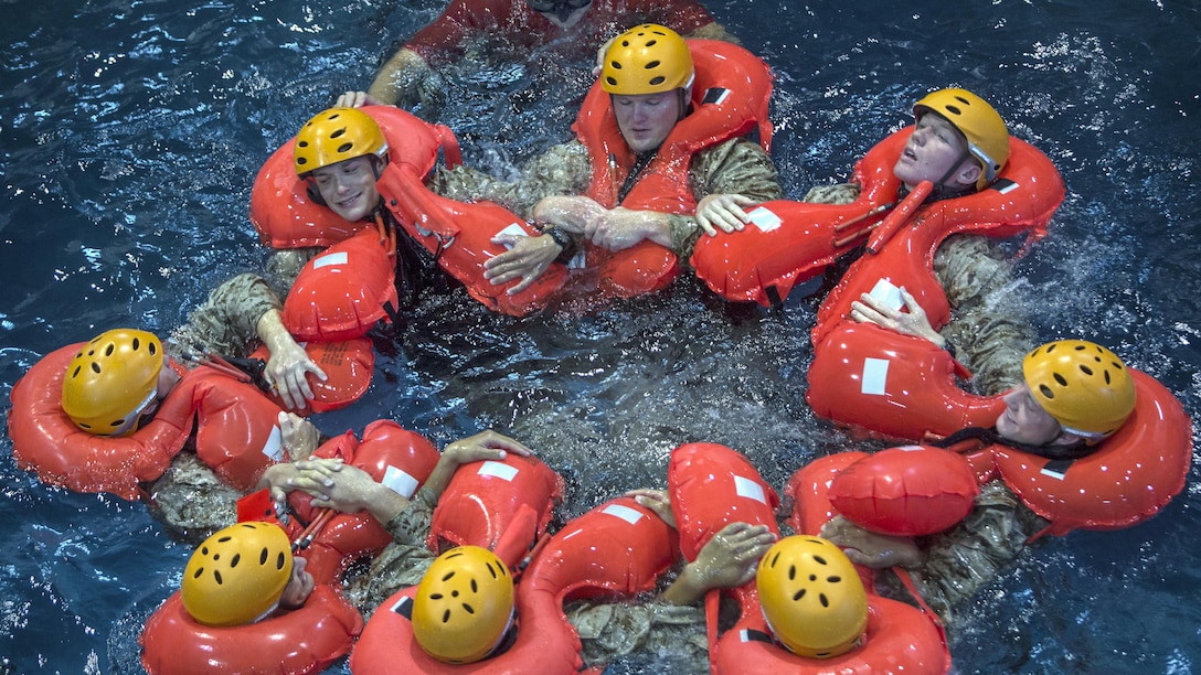 Marines huddle together to stay afloat during open-water survival training at Naval Station Rota, Spain, July 25, 2017. The training consisted of water familiarization, rappelling into a life raft and disengaging from a downed aircraft while underwater. The Marines are assigned to assigned to the command and ground combat elements of the Special Purpose Marine Air-Ground Task Force-Crisis Response Africa. Marine Corps photo by Staff Sgt. Kenneth K. Trotter Jr.