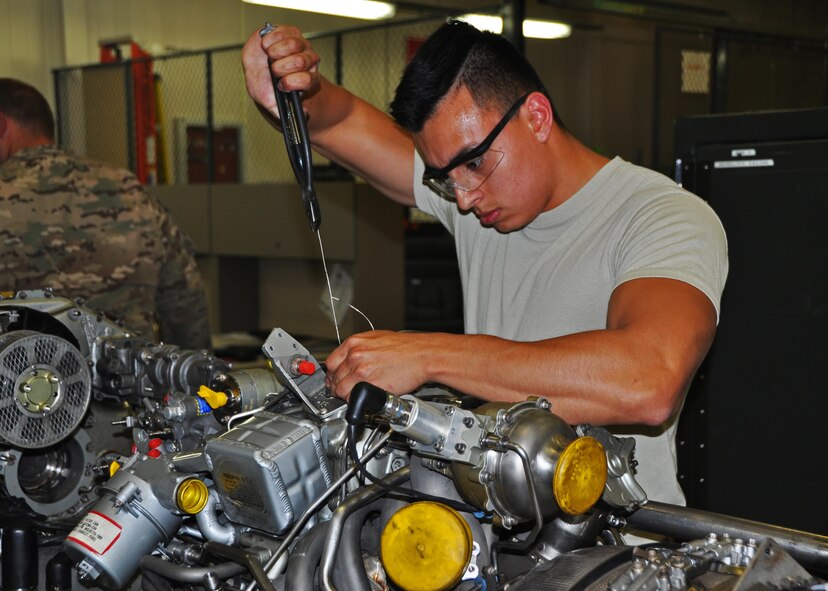 Senior Airman Stephen Cruz, a 592nd Special Operations Maintenance Squadron propulsion technician, connects a safety wire on a C-146 engine component at Duke Field, Fla., recently.  The active-duty squadron works alongside its Air Force Reserve maintenance counterparts at Duke to maintain engines on both C-145 and C-146 aircraft. (U.S. Air Force photo/Dan Neely)