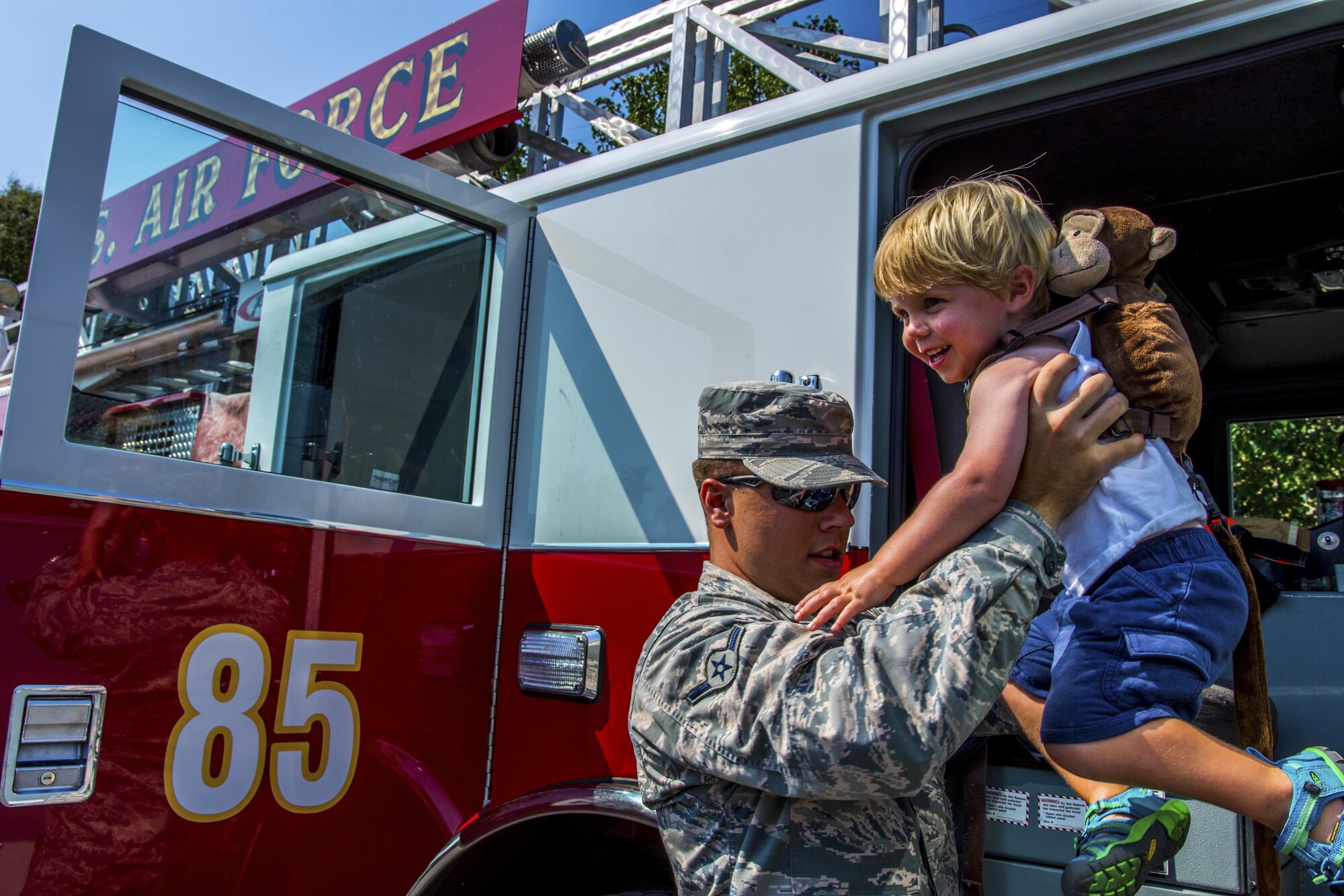 Airman Basic Bryce Postle, 445th Airlift Wing journeyman firefighter, helps a toddler out of a fire engine during Big Truck Day, July 28, Destin, Fla. A 96th Civil Engineer Group fire engine was on display and firefighters educated the community about fire safety. Fire, construction, garbage and utility trucks were on display for kids to see up close at the city’s annual event. (U.S. Air Force photo/Kristin Stewart)
