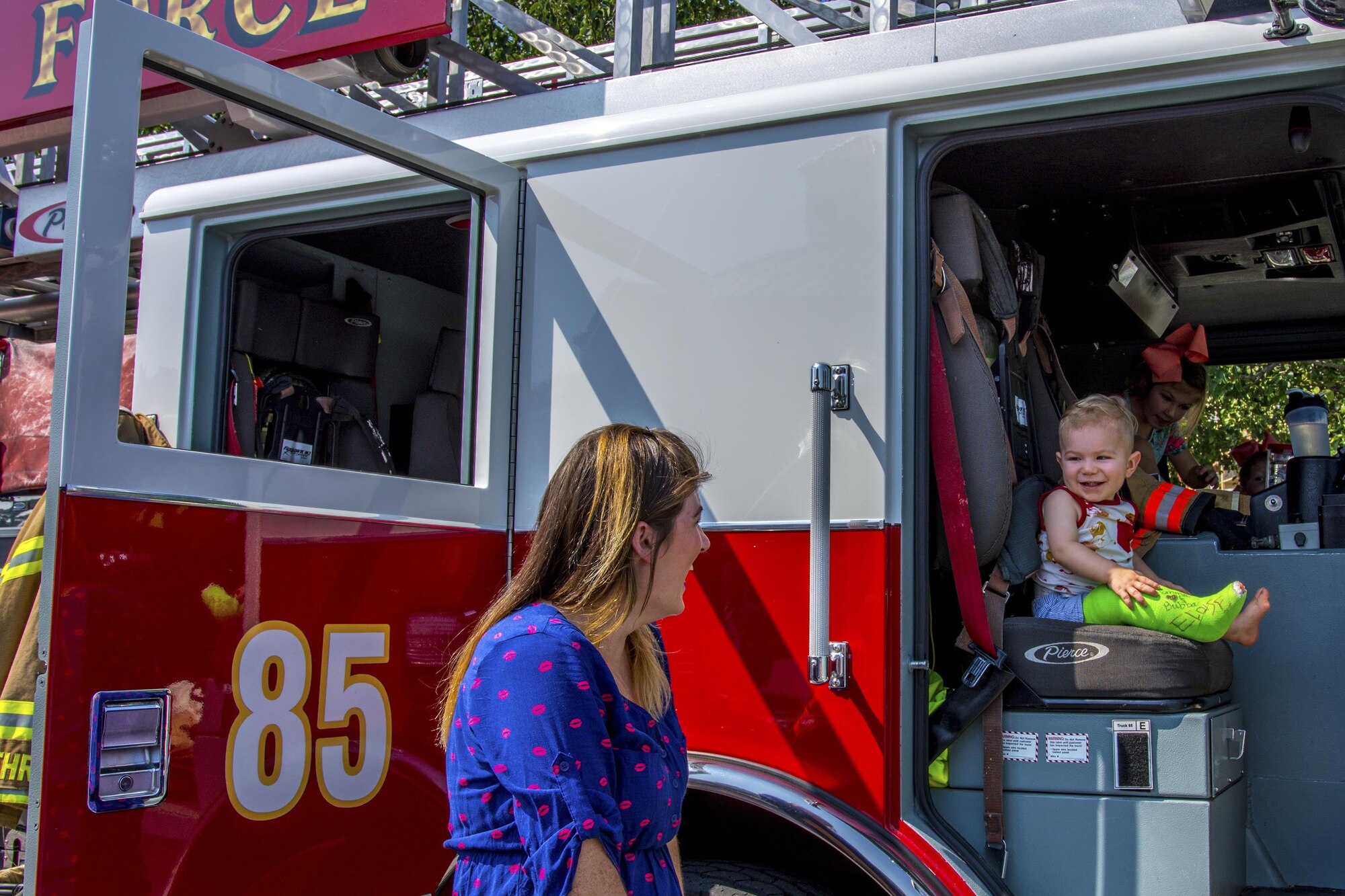 While he sits in a fire engine for the first time, his mom smiles back. A 96th Civil Engineer Group fire engine was on display and firefighters educated the public on fire safety at Big Truck Day, July 28, Destin, Fla. Fire, construction, garbage and light power trucks were on display for kids to see up close at the city’s annual event. (U.S. Air Force photo/Kristin Stewart)