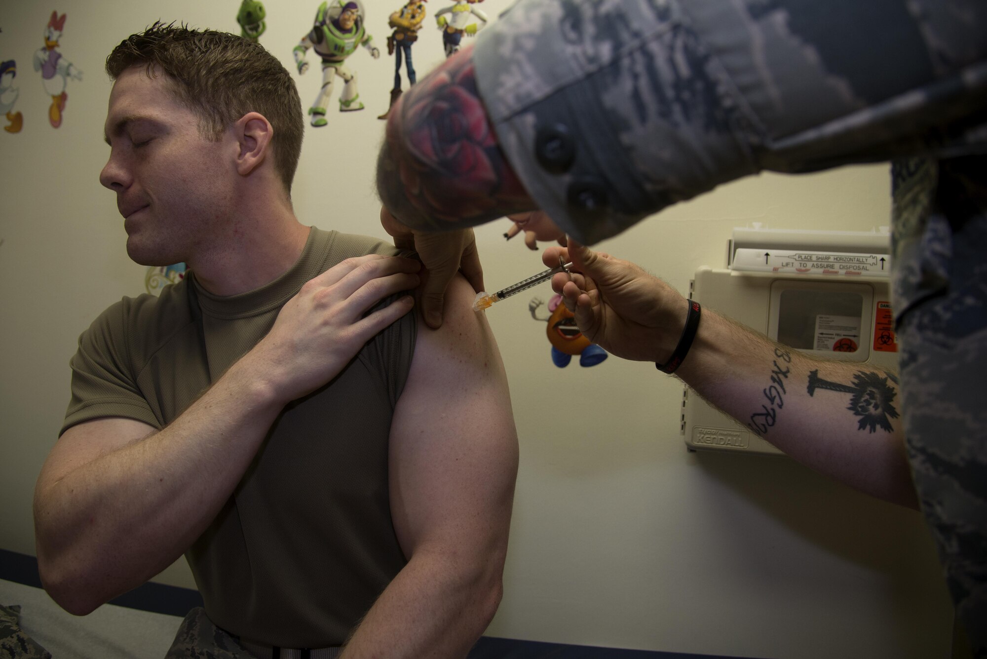 Staff Sgt. Brandon Issler receives a vaccination from Staff Sgt. Michael Teague, a 932nd Aerospace Medical Squadron aerospace medicine technician, at the Vance Clinic July 21. This year, for their annual tour, the 932nd AMDS trained with the 71st Medical Group at Vance. (U.S. Air Force photo/ Airman Zachary Heal)