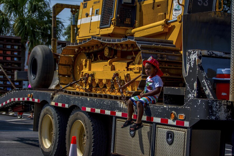 A young boy sits next to a Jackson Guard bulldozer, used to clear debris for prescribed fires, during Big Truck Day July 28, Destin, Fla. Jackson Guard forestry management personnel educated the community about the benefits of prescribed burns. Fire, construction, garbage and utility trucks were on display for kids to see up close at the city’s annual event. (U.S. Air Force photo/Kristin Stewart)