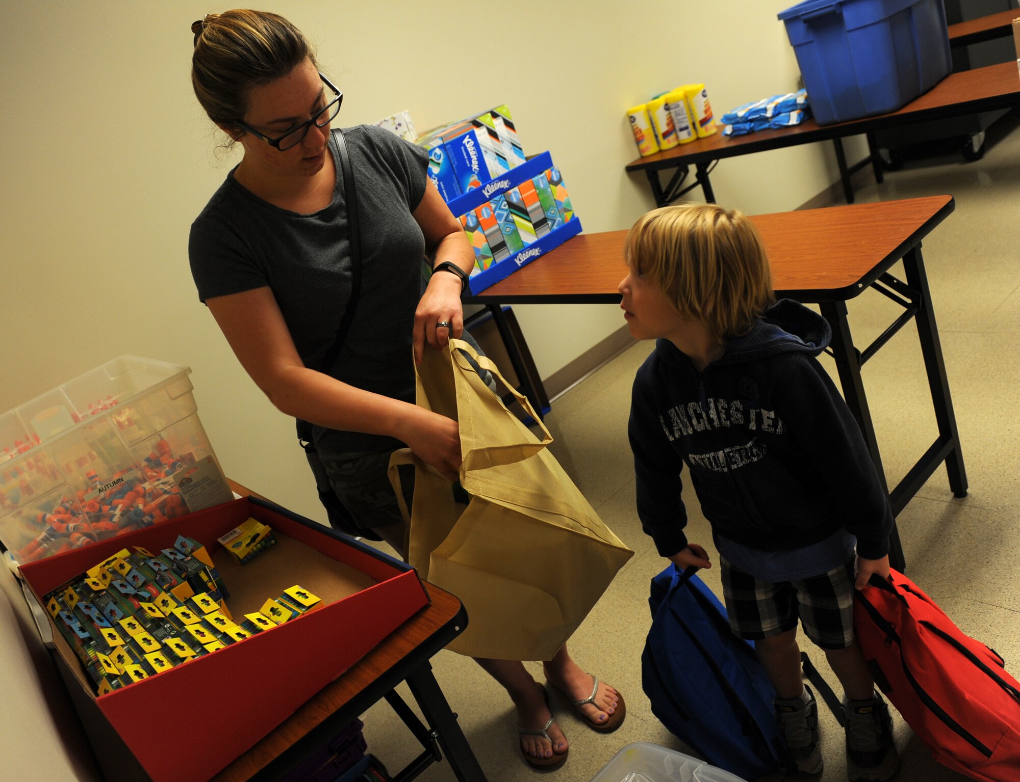 A spouse and son, select school supplies during the School Supply Giveaway, July 31, 2017, at McConnell Air Force Base, Kan. The supplies were donated by Operation Homefront, a nonprofit organization whose goal is to help build strong, stable and secure military families. (U.S. Air Force photo/Staff Sgt. Rachel Waller)