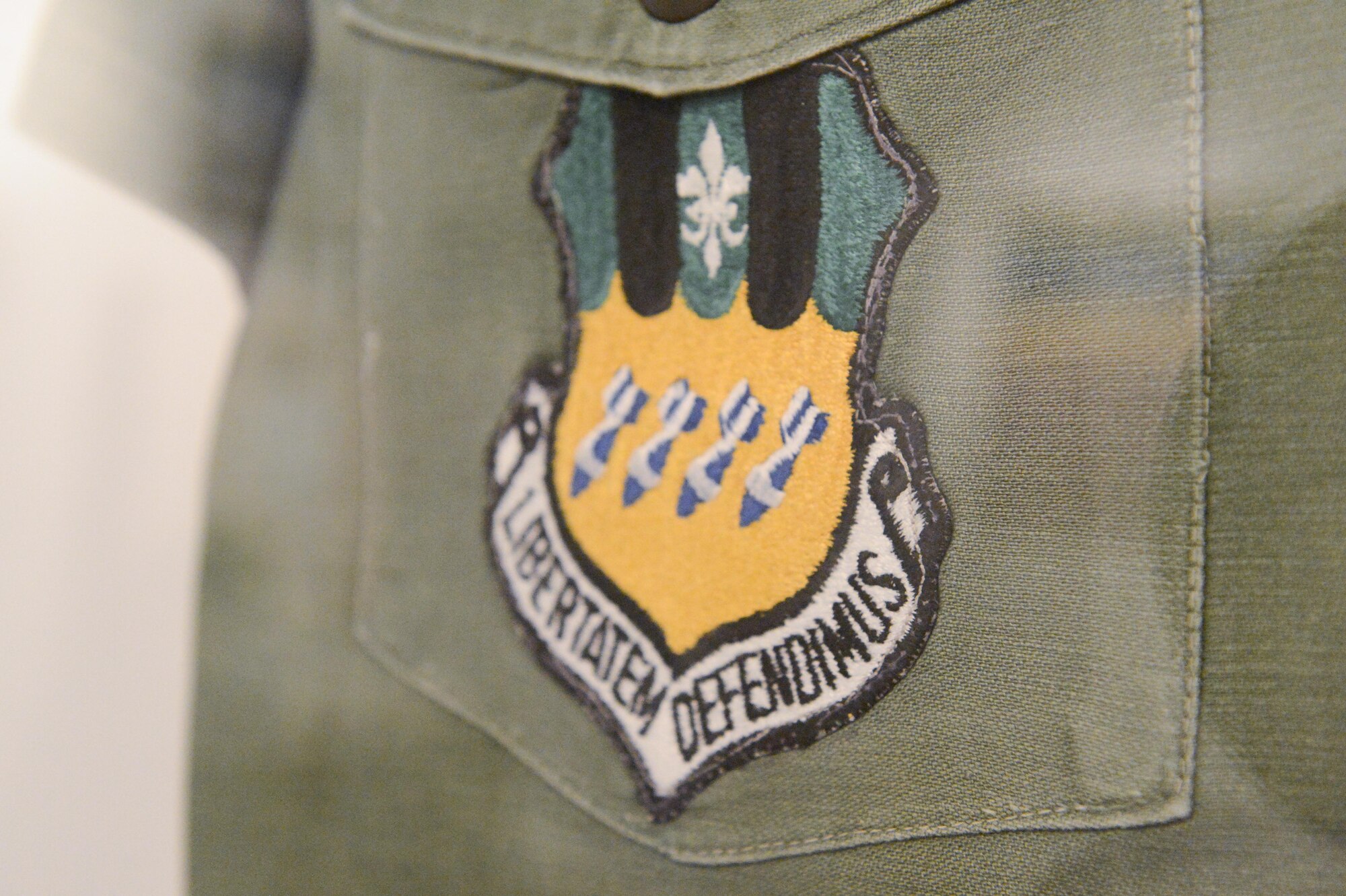 A 2nd Bomb Wing patch is worn on a Strategic Air Command crew chief shirt on display in the Barksdale Global Power Museum on Barksdale Air Force Base, La., July 12, 2017. The 2nd BW is the oldest bomb group in the Air Force. The bombs represent the original squadrons, the stripes represent major World War I offensives and the white fleur de lis represents the French location of battles.