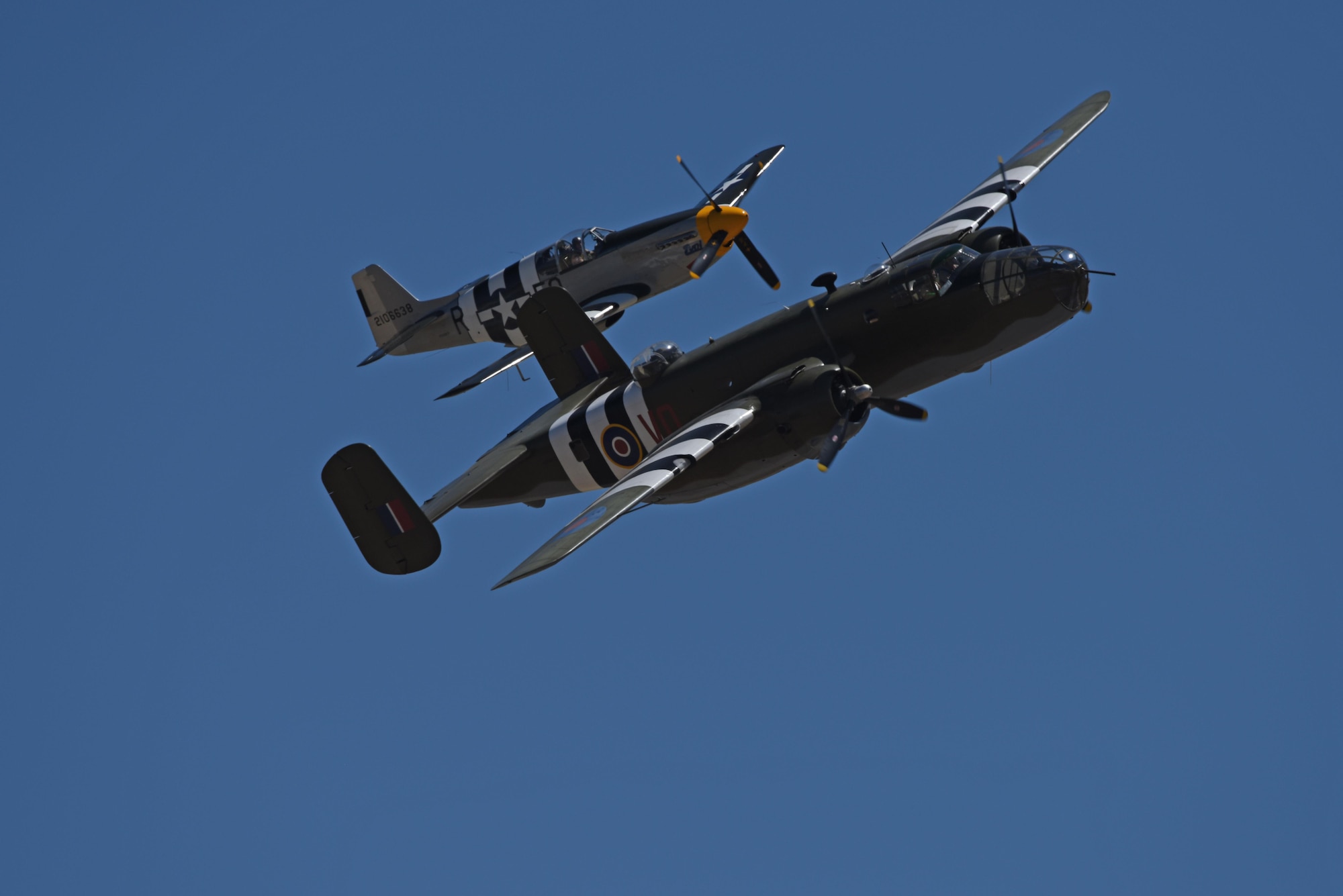 A B-25 Bomber and a P-51 Mustang perform during the 2017 Skyfest Air Show and Open House July 29, 2017, at Fairchild Air Force Base, Washington. The invasion stripes upon on the aircraft were painted on the fuselages and wings of World War II allied aircraft to increase recognition by friendly forces. (U.S. Air Force photo/Airman 1st Class Jesenia Landaverde)