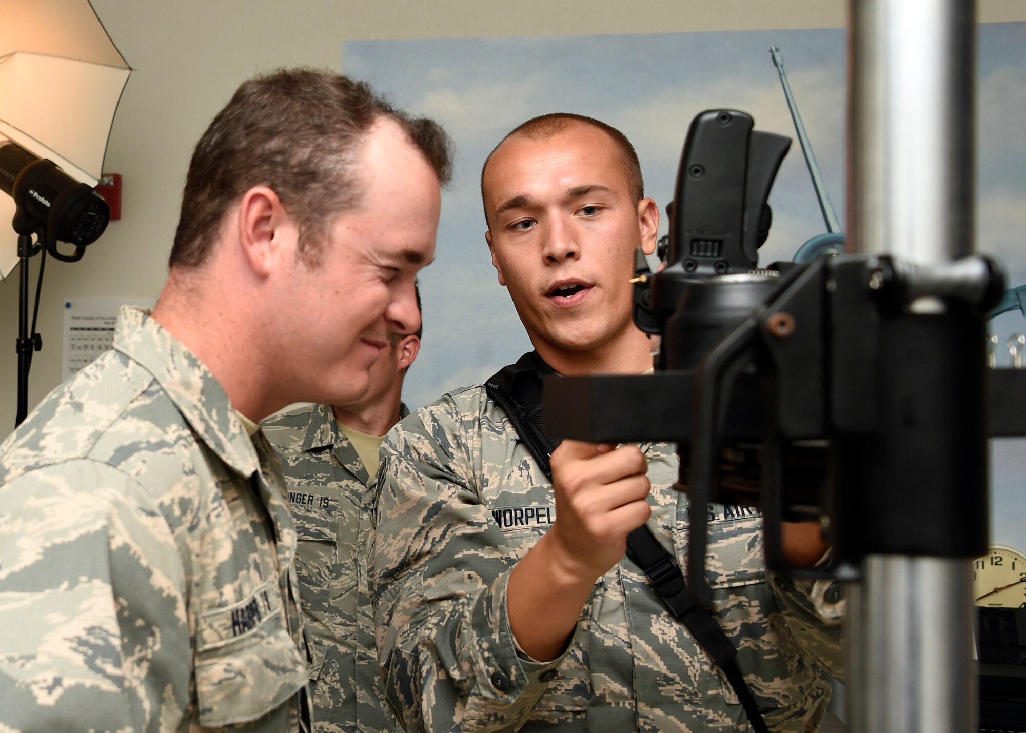 Airman 1st Class Caleb Worpel, 56th Fighter Wing photojournalist, shows a U.S. Air Force Academy cadet how to operate a camera during their tour July 31, 2017 at Luke Air Force Base, Ariz. Several cadets from the U.S. Air Force Academy received an in-depth look at how Luke achieves its mission of building the future of airpower. (U.S. Air Force photo by Senior Airman Devante Williams)  