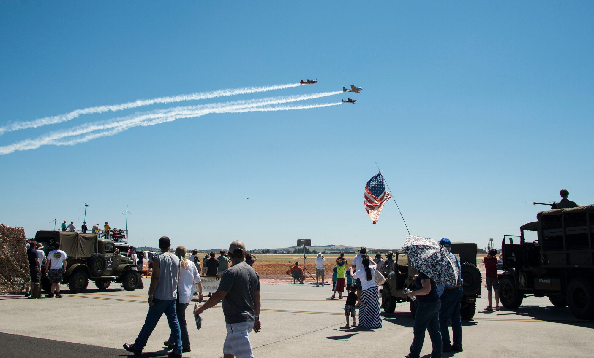 Service members and members of the local community watch as the Cascade Warbirds perform during the Skyfest 2017 Air Show and Open House at Fairhcild Air Force Base, Washington, July 29, 2017. SkyFest was an opportunity to give the local and regional community a chance to view Airmen and our resources. (U.S. Air Force photo/Senior Airman Janelle Patiño)