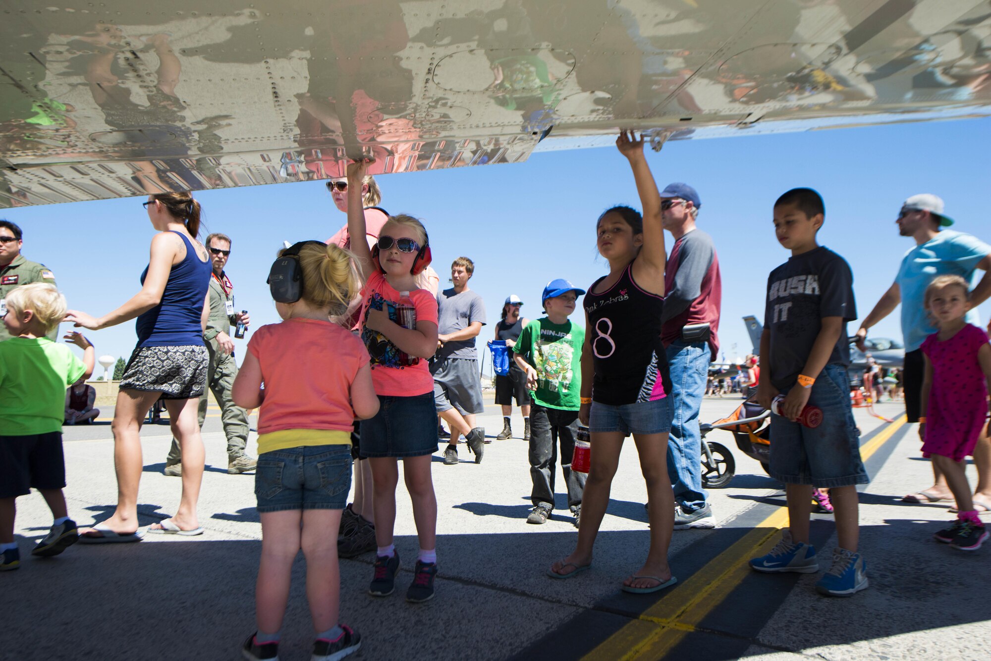 Members from the local and regional community touch the wing of a static display aircraft during SkyFest 2017 Air Show and Open House at Fairchild Air Force Base, Washington, July 30, 2017. SkyFest hosted more than 15 types of aircraft and static displays and more than 10 flying performers. (U.S. Air Force photo/Senior Airman Janelle Patiño)