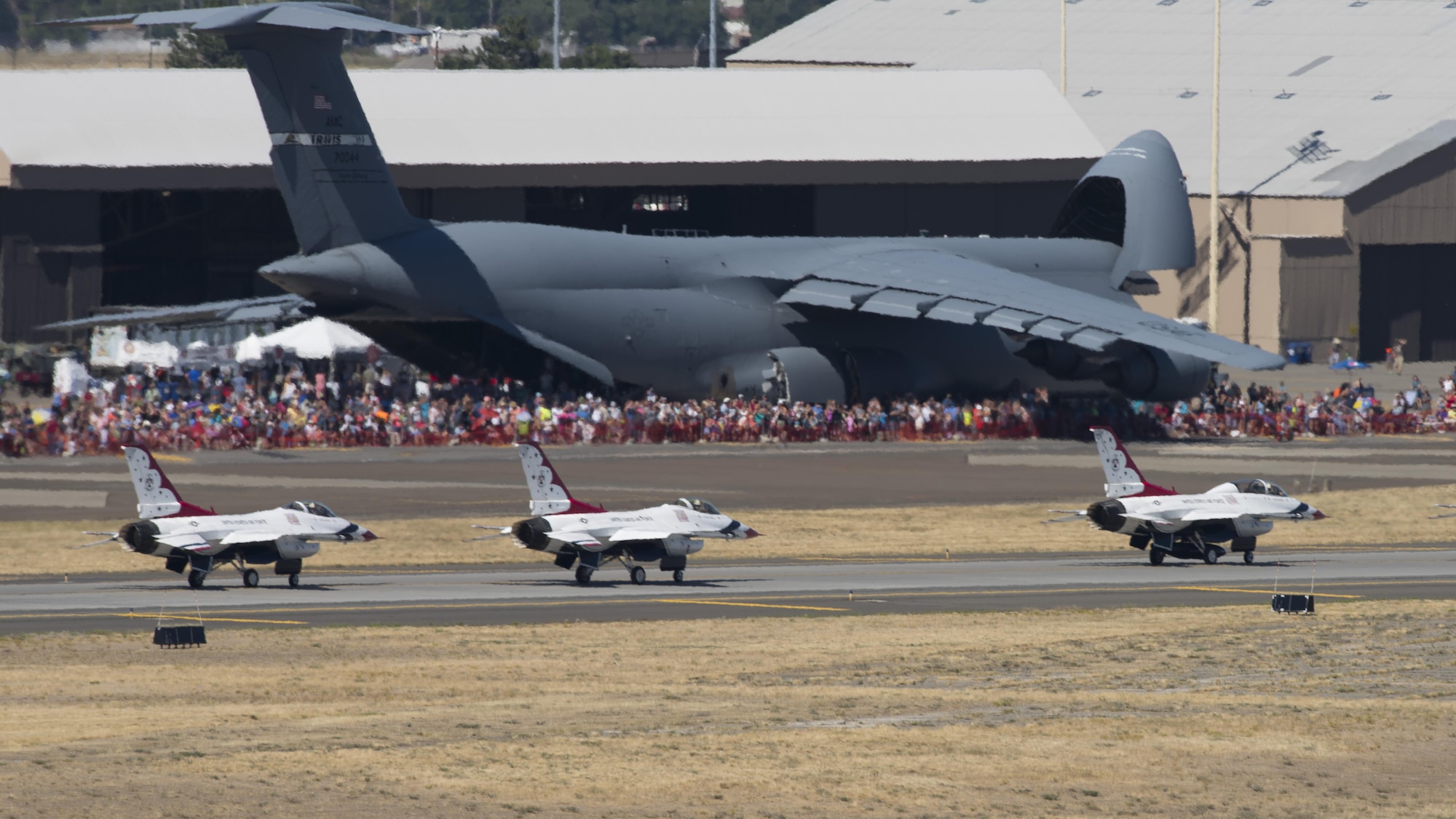 The Thunderbirds aerial demonstration team taxi in front of a C-5 Galaxy and hundreds of attendees at the Skyfest 2017 air show and open house July 30, 2017, at Fairchild Air Force Base, Washington. Thousands attended the first Fairchild air show in three years, helping the base to celebrate it's 75th anniversary. (U.S. Air Force photo / Airman 1st Class Ryan Lackey)