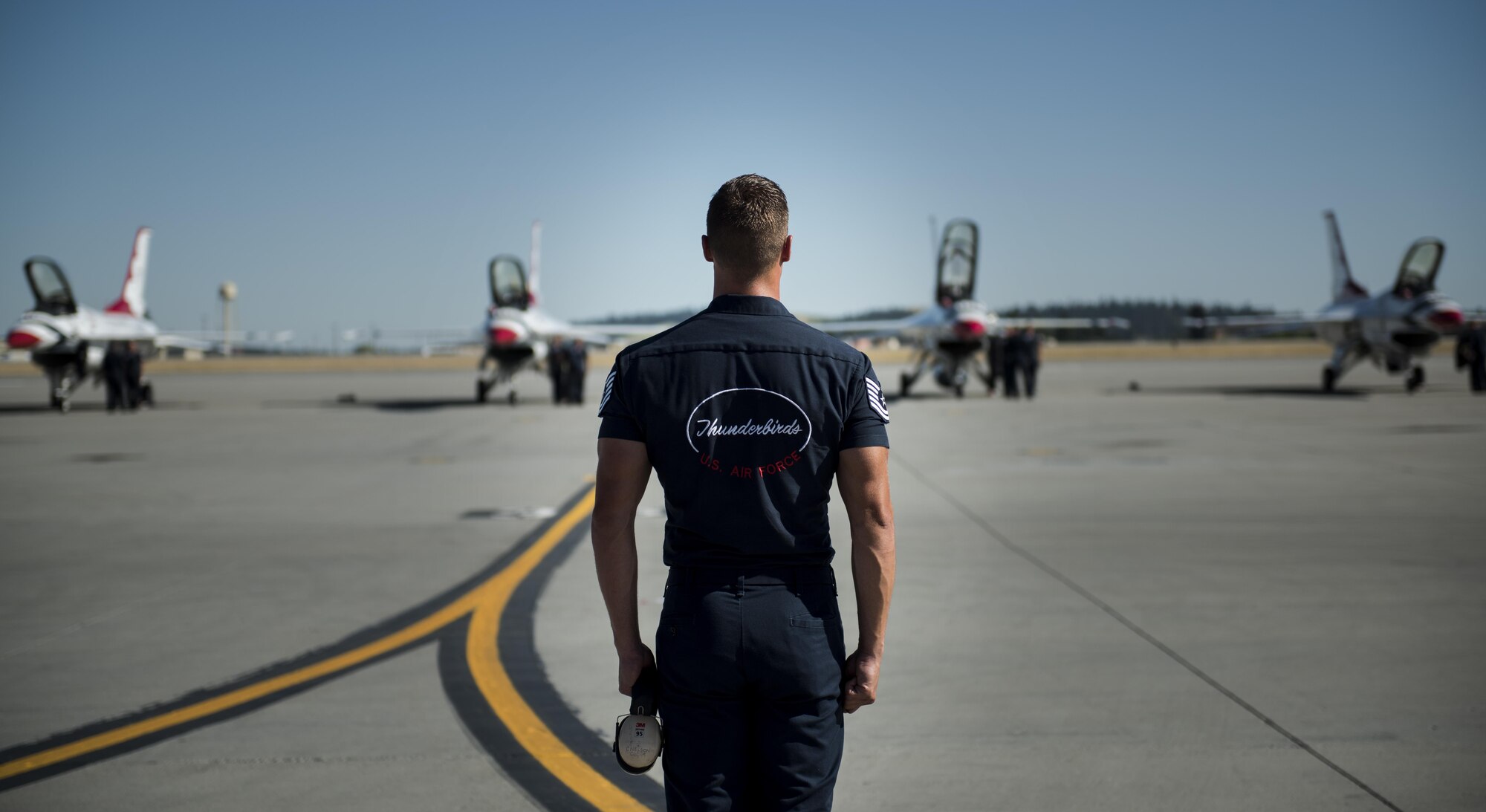 A U.S. Air Force Aerial Demonstration Squadron Thunderbird maintainer looks out as other Thunderbirds finish their performances at Skyfest 2017 Air Show and Open House July 30, 2017, at Fairchild Air Force Base, Washington. The Thunderbirds are the Air Force’s premiere aerial demonstration team who perform at various military bases and civilian air shows around the world. (U.S. Air Force photo/ Senior Airman Sean Campbell) 