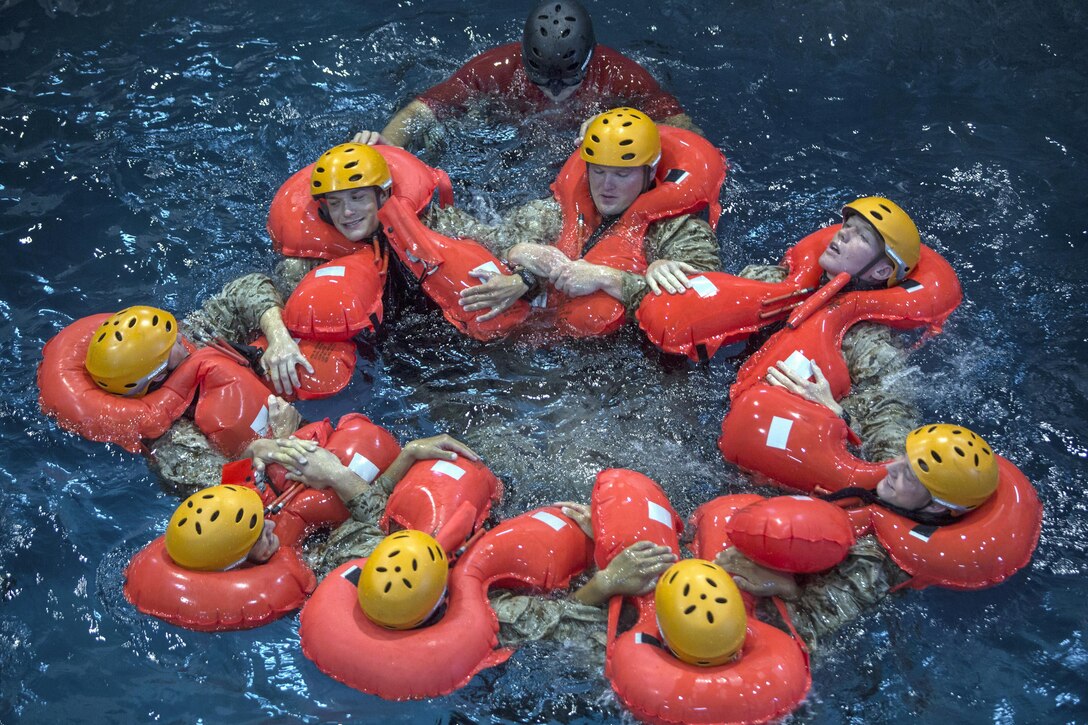 Marines huddle together to stay afloat during open-water survival training at Naval Station Rota, Spain, July 25, 2017. The training consisted of water familiarization, rappelling into a life raft and disengaging from a downed aircraft while underwater. The Marines are assigned to assigned to the command and ground combat elements of the Special Purpose Marine Air-Ground Task Force-Crisis Response Africa. Marine Corps photo by Staff Sgt. Kenneth K. Trotter Jr.