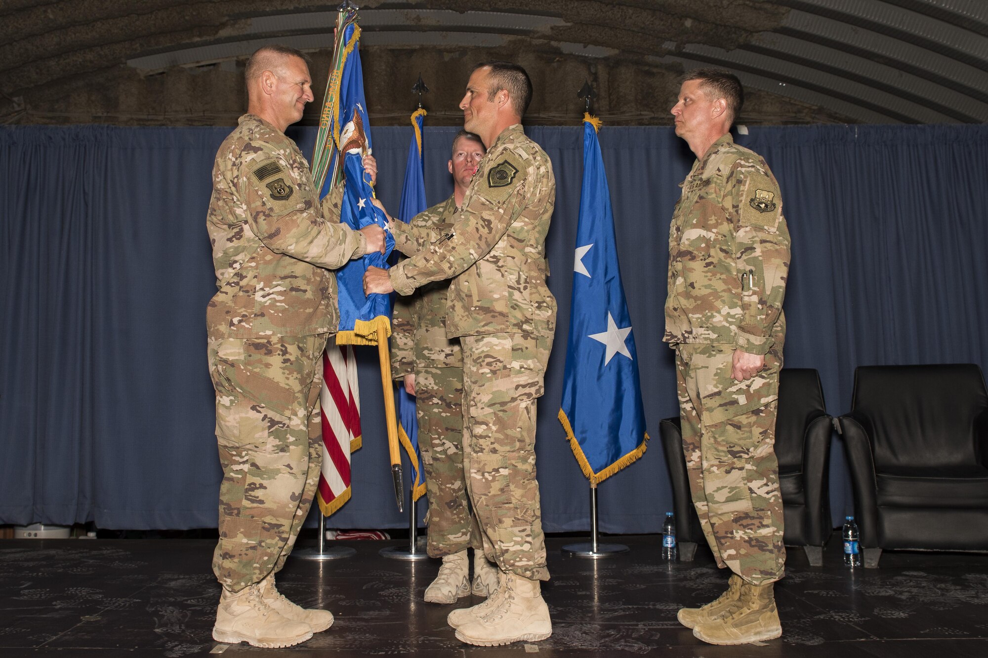 Col. Clinton W. Eichelberger, 332nd Air Expeditionary Wing commander, middle, relinquishes the guidon to Maj. Gen. Dirk D. Smith, 9th Air Expeditionary Task Force-Levant commander, during a change of command ceremony May 31, 2017 in Southwest Asia. The passing of a wing’s guidon symbolizes a transfer of command. (U.S. Air Force photo/Senior Airman Damon Kasberg)