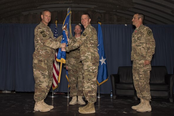 Maj. Gen. Dirk D. Smith, 9th Air Expeditionary Task Force-Levant commander, left, passes the guidon to Brig. Gen. Kyle W. Robinson during the 332nd Air Expeditionary Wing change of command ceremony May 31, 2017 in Southwest Asia. The passing of a wing’s guidon symbolizes a transfer of command. (U.S. Air Force photo/Senior Airman Damon Kasberg)