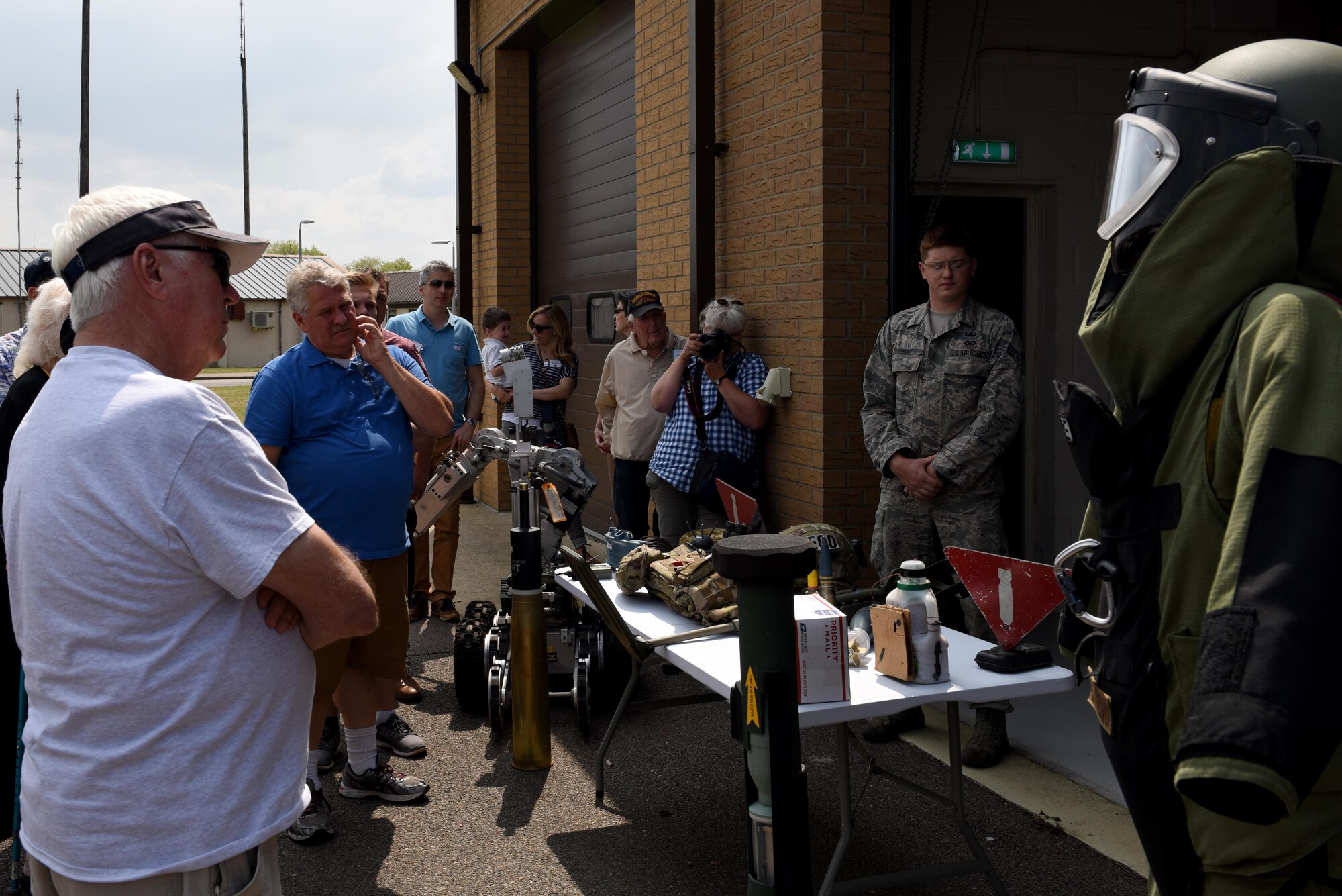 Members of the 305th Bomb Wing Heritage Group listen to a brief about Explosive Ordinance Disposal techniques and equipment at Royal Air Force Lakenheath, May 25. RAF Lakenheath hosts community tours around the base to help the community get a look behind the scenes at the Air Force mission in Europe. (U.S. Air Force photo/Airman 1st Class John A. Crawford)