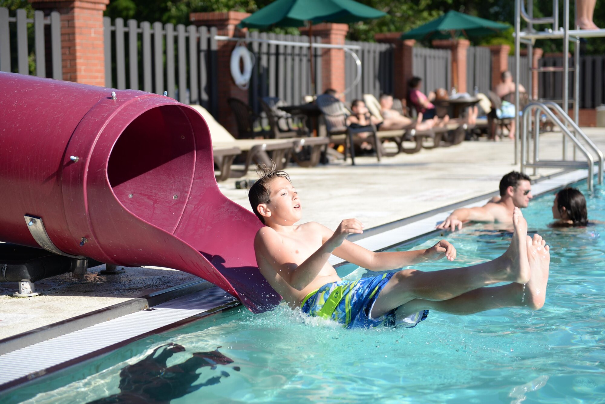 Connor Tolliver, son of Chief Master Sgt. Tracy Tolliver, 14th Medical Group Superintendent, slides down the slide at the Independence Pool opening May 26, 2017, on Columbus Air Force Base, Mississippi. The pool opening Luau Party featured a buffet with games and music. The pool is open daily from noon – 7 p.m. (U.S. Air Force photo by Senior Airman John Day)