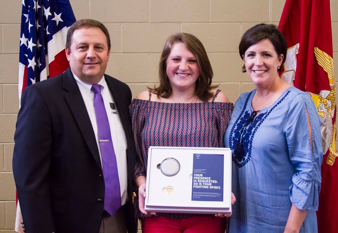 Gracyn LeSueur (center) poses for a photo with her father, Kevin LeSueur (left), and mother Michelle LeSueur (right) after being presented with the Semper Fidelis All-American award at Northview High School, May 18, 2017. “I want to thank my mom and dad for never giving up on me, and pushing me to be what I am today,” LaSueur said. LaSueur will attend the Battles Won Academy this summer in Washington D.C., where she will be given the opportunity to network with and hear from an elite circle of leaders from all walks of life, who like her, have fought and won their own battles. (U.S. Marine Corps photo by Cpl. Krista James/Released)