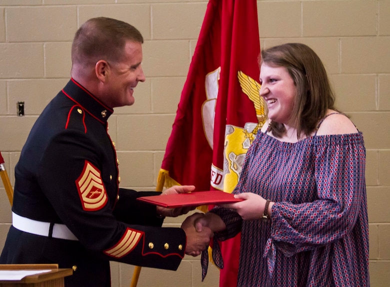 Gunnery Sgt. Matthew Hoyle, the station commander for Recruiting Substation Dothan, Alabama, presents a certificate to Gracyn LaSueur, who was chosen as one of a 100 Semper Fidelis All-Americans, at Northview High School, May 18, 2017. The Marine Corps wanted to find young student athletes who encompass the core values of honor, courage and commitment. These are the Semper Fidelis All-Americans. These students have faced life’s battles with the conviction and determination to succeed. They embody the same fighting spirit that Marines stand for by taking on their own challenges and succeeding academically, while excelling in athletics and making their community a better place. (U.S. Marine Corps photo by Cpl. Krista James/Released)