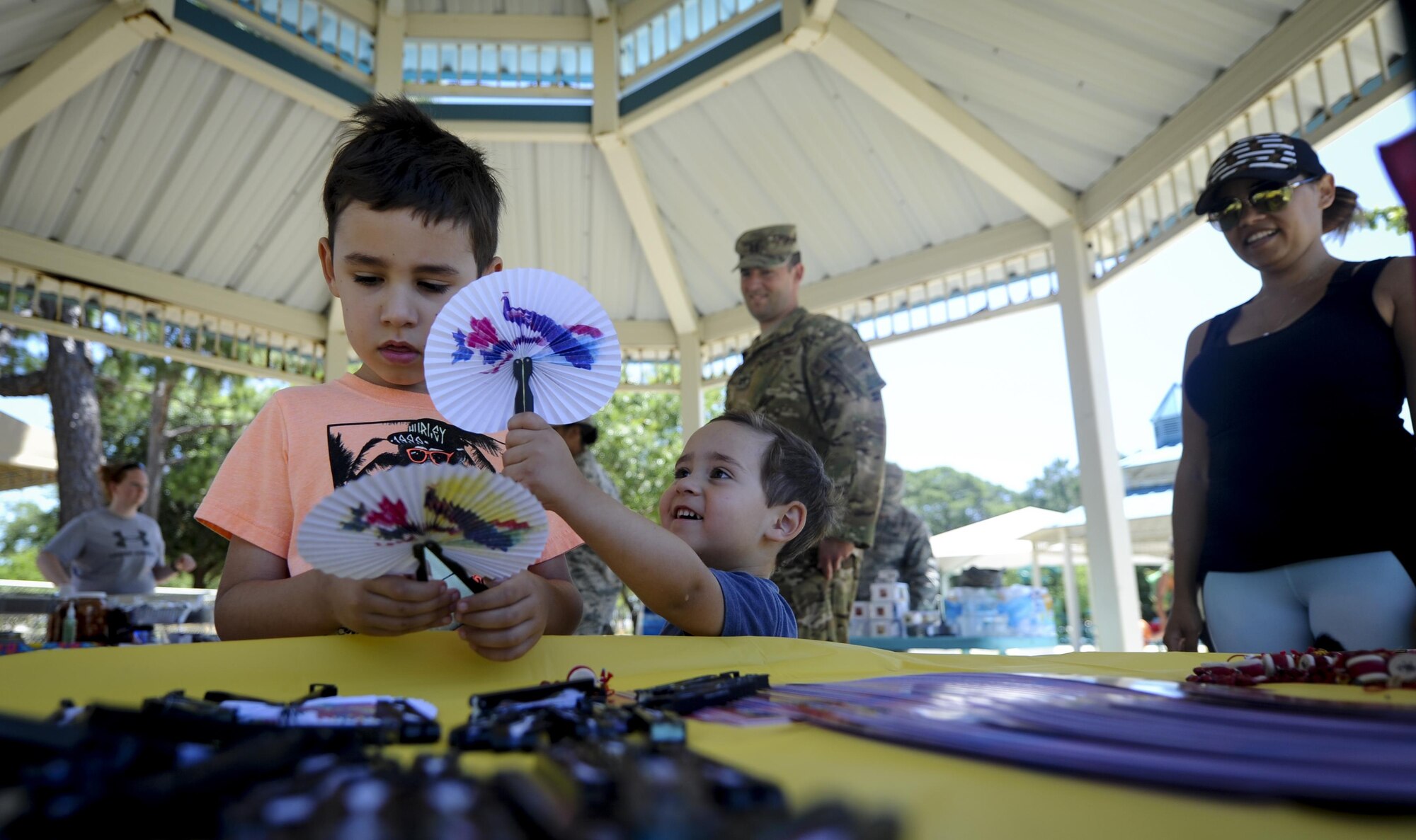 Damien and Daniel Wright, sons of Capt. Tim Wright, a gunship electronic warfare officer with the 4th Special Operations Squadron, play with fixed fans at the Asian American and Pacific Islander Cultural Day event at Hurlburt Field, Fla., May 25, 2017. The event included free food, a Kuk Sool Won demonstration and a hula demonstration. (U.S. Air Force photo by Airman 1st Class Dennis Spain)