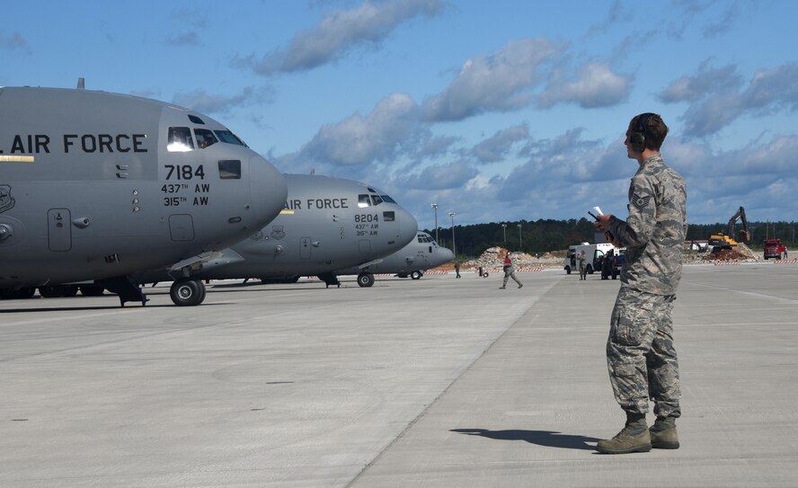 Tech. Sgt. Mark Johnson, with the 43d Air Mobility Squadron, ensures everything runs smoothly with the 2000 paratroopers being loaded onto C-17 Globemaster lll aircraft. More than 20 C-17 Globemaster IIIs flew from JB Charleston to pick up heavy cargo and 2,000 paratroopers to deliver them to a drop zone on Fort Bragg, N.C. during All American Week. (U.S. Air Force photo by Tech. Sgt Jamie Powell)
