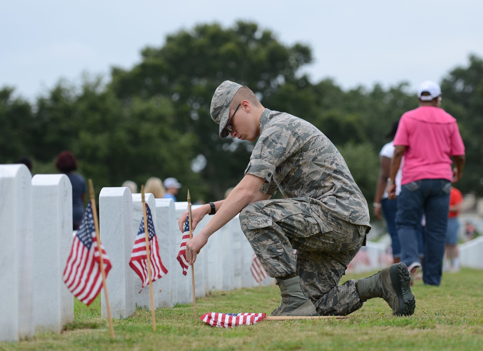 Airman Basic Charlie Evans, 335th Training Squadron student, places a U.S. flag in front of a tomb stone at Biloxi National Cemetery in recognition of Memorial Day, May 27, 2017, in Biloxi, Miss. Local veterans, family members and Keesler AFB personnel participated in the event to honor and remember the lives of fallen heroes of the U.S. military. (U.S. Air Force photo by Andrew Whitman)