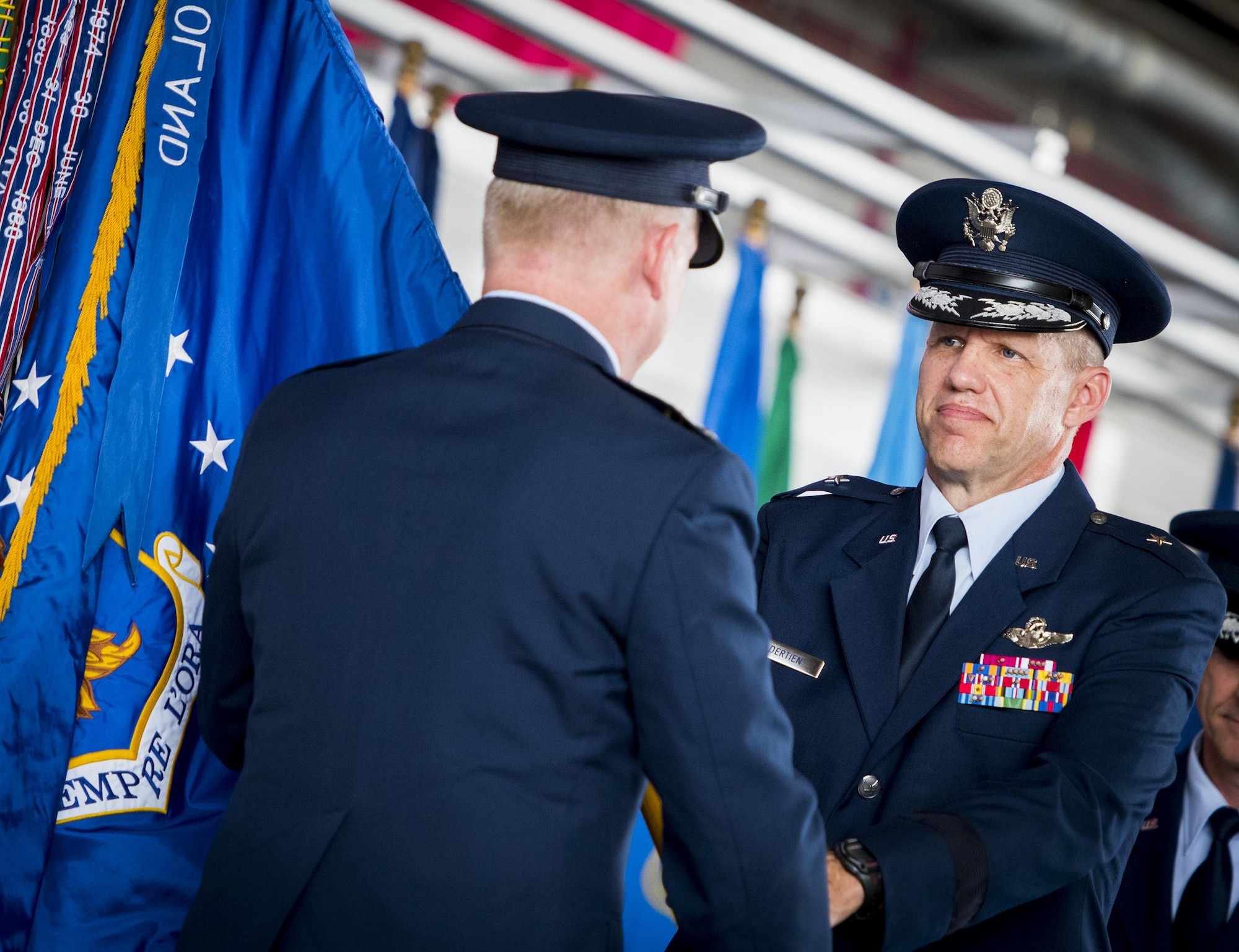 Brig. Gen. Evan Dertien accepts the 96th Test Wing guidon from Maj. Gen. David Harris, Air Force Test Center commander, during the wing's change of command ceremony at Eglin Air Force Base, Fla., May 31. Brig. Gen. Christopher Azzano relinquished command to Dertien.  The command position is Dertien’s third assignment to Team Eglin. (U.S. Air Force photo/Samuel King Jr.)