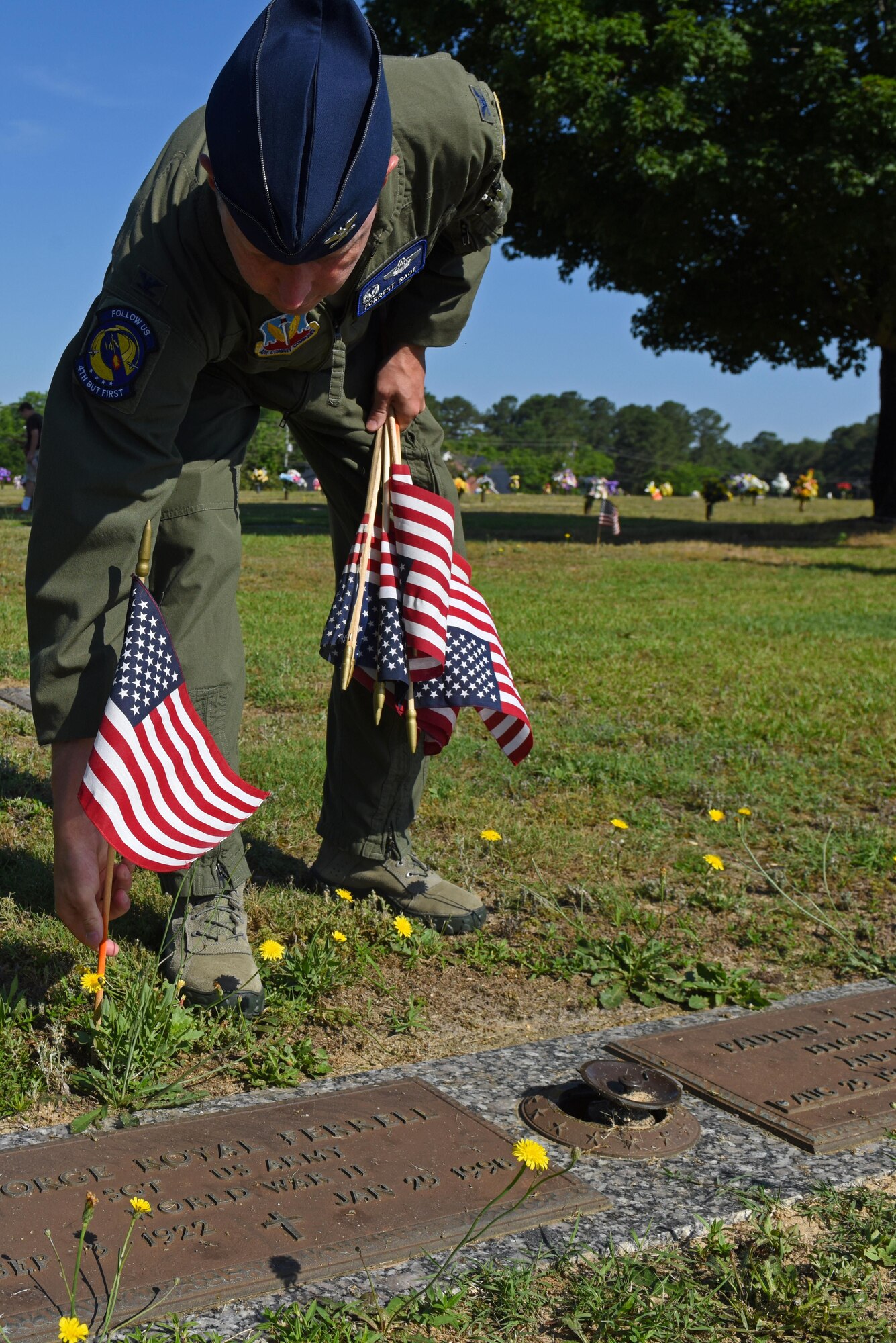Col. Christopher Sage, 4th Fighter Wing commander, 
places a flag behind a headstone of a veteran, May 27, 2017, at Wayne Memorial Park in Dudley, North Carolina. Sage spoke at a breakfast hosted by the Wayne County Veterans & Patriots Coalition then assisted in distributing flags on veterans’ final resting places. (U.S. Air Force photo by Senior Airman Ashley Maldonado-Suarez)