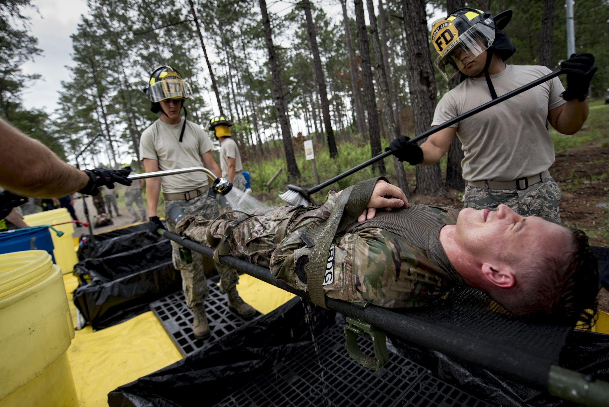 Members of the 23d Civil Engineer Squadron fire department conduct decontamination procedures during a simulated explosives and hazardous material scenario, May 25, 2017, at Moody Air Force Base, Ga. The exercise simulated initial responses from first responders who then contacted other appropriate units after assessing the potential threat while also assisting the simulated victims of hazardous materials. (U.S. Air Force photo by Airman 1st Class Daniel Snider)