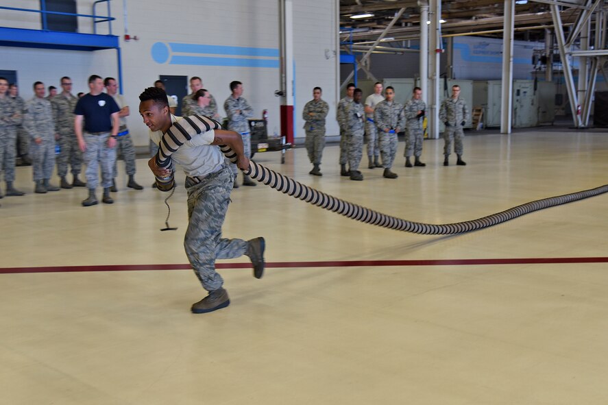 Senior Airman Kendall Dean, 92nd Aircraft Maintenance Squadron sortie support debrief section member, completes the second phase of the 2017 Spring Maintenance Olympics relay race May 26, 2017, at Fairchild Air Force Base. Airmen had to unravel two air cart hoses and drag them across the hangar floor to where their teammate was waiting to connect the hoses to a ‘y’ fitting. (U.S. Air Force photo/Senior Airman Mackenzie Richardson)