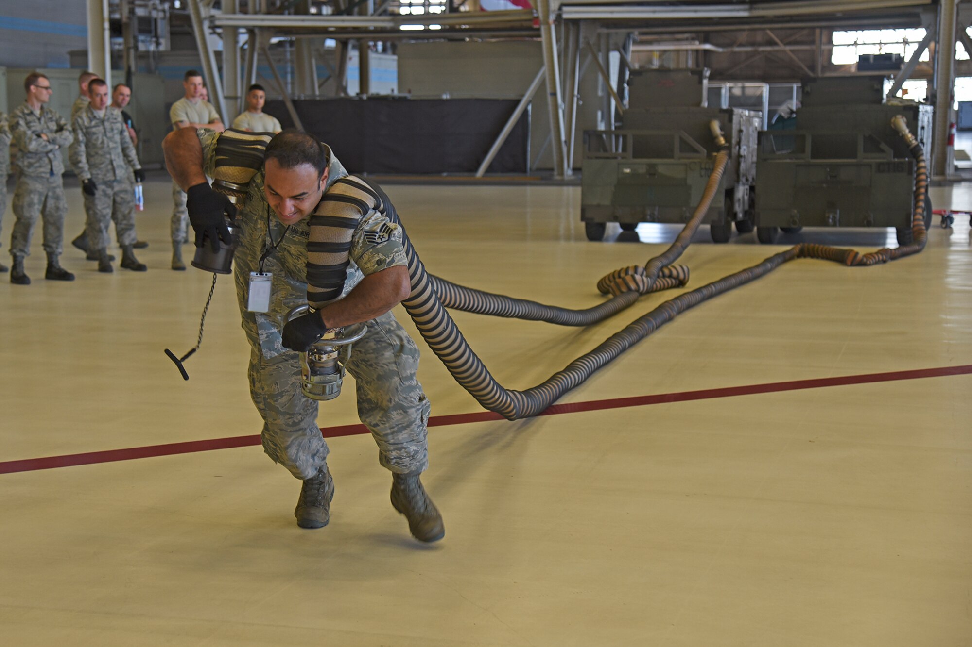 Staff Sgt. Lemuel Robledo, 92nd Maintenance Squadron fuel systems craftsman, pulls two air car hoses during the 2017 Spring Maintenance Olympics relay race May 26, 2017, at Fairchild Air Force Base. The relay race included various maintenance tasks such as checking a toolbox for quality assurance fails, retrieving a streamer from a fuel cell trainer and taking a short maintenance quiz that could ultimately knock time off of the relay race. (U.S. Air Force photo/Senior Airman Mackenzie Richardson)