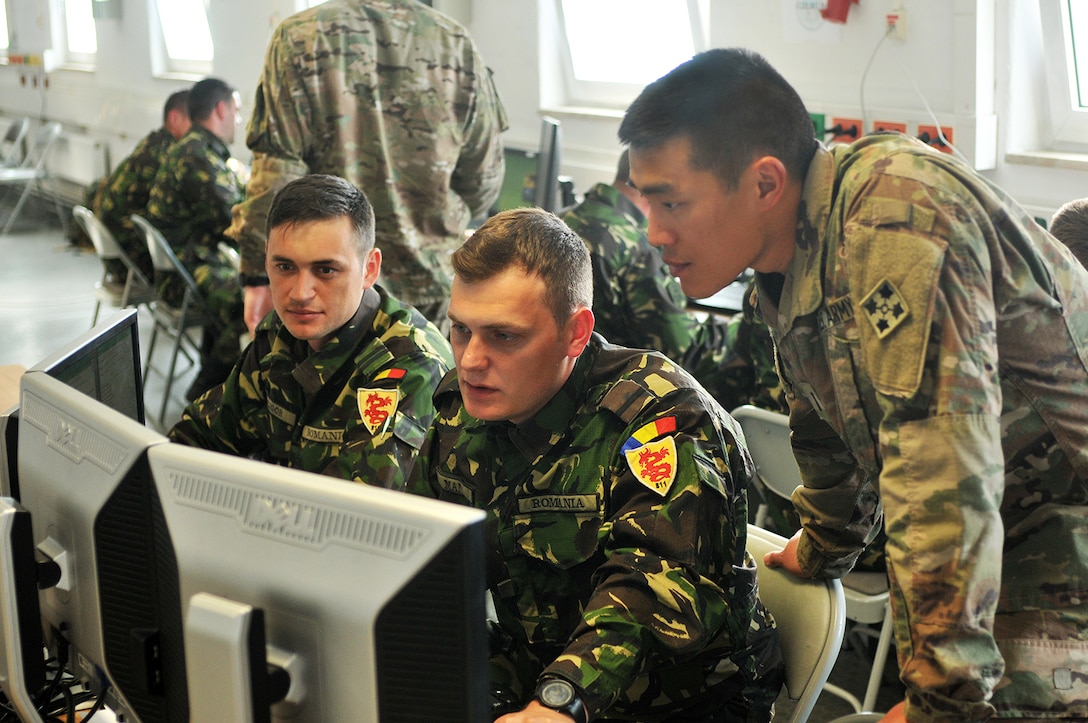 From left, Romanian army 1st Lt. Sergio Gligor, an operations officer, and 2nd Lt. Andrei Ma, a battle captain, both with the 811th Infantry Battalion, and U.S. Army 1st Lt. Jeff Yao, a military intelligence officer with the 3rd Armored Brigade Combat Team, 4th Infantry Division, track a counterattack in a simulated fight against a conventional force during a command-post exercise conducted at Grafenwoehr Training Area, Germany, May 16, 2017. Army photo by Capt. Scott Walters