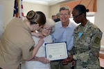 Defense Logistics Agency Aviation’s Marine Sgt. Caitlyn Baker decorates Bertha Steward, a veteran of the Women’s Army Corp and resident, with a Memorial Day medal as Fort Lee’s Army Master Sgt. Pamela Whitlock presents her a certificate of appreciation at the Crossings at Iron Bridge Memorial Day ceremony May 26, 2017.