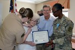 Defense Logistics Agency Aviation’s Marine Sgt. Caitlyn Baker decorates Bertha Steward, a veteran of the Women’s Army Corp and resident, with a Memorial Day medal as Fort Lee’s Army Master Sgt. Pamela Whitlock presents her a certificate of appreciation at the Crossings at Iron Bridge Memorial Day ceremony May 26, 2017.