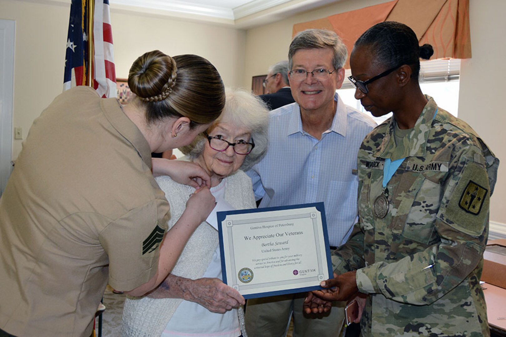 Defense Logistics Agency Aviation’s Marine Sgt. Caitlyn Baker decorates Bertha Steward, a veteran of the Women’s Army Corp and resident, with a Memorial Day medal as Fort Lee’s Army Master Sgt. Pamela Whitlock presents her a certificate of appreciation at the Crossings at Iron Bridge Memorial Day ceremony May 26, 2017.