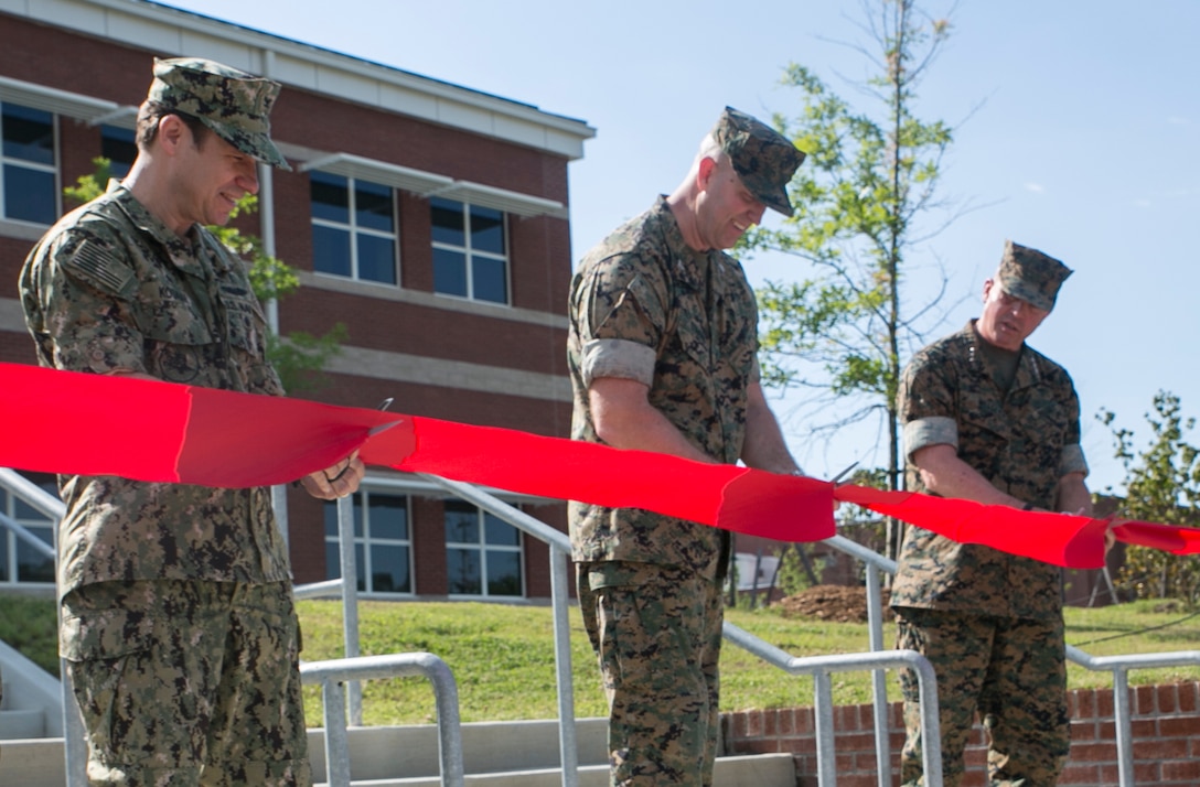 (From right to left) Lt. Gen. John E. Wissler, Commander, U.S. Marine Corps Forces Command, Col. John Evans, Commanding Officer, U.S. Marine Corps Security Force Regiment, and Navy Capt. Matthew Kosnar, Base Commander, Naval Weapons Station Yorktown, take part in a ribbon-cutting ceremony June 1, aboard Naval Weapons Station Yorktown, Va., for the official opening of the new Marine Corps Security Force Regiment Headquarters building. This was the beginning step to co-locating the three Fleet Anti-Terrorist Security Team companies that are currently scattered within the Hampton Roads area. (U.S. Marine Corps photo by Sgt. Kayla D. Rivera/Released)