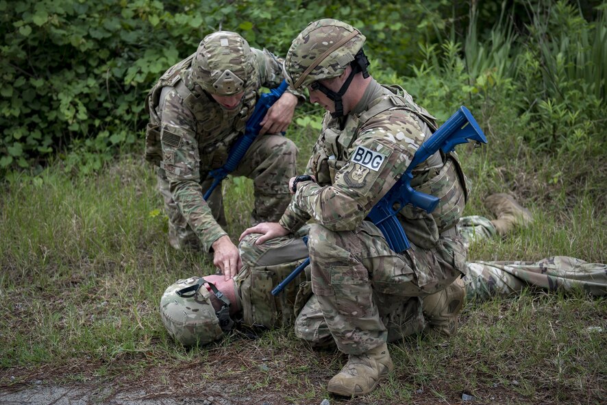 Senior Airman Jonah Phillips, 822d Base Defense Squadron fireteam member and Staff Sgt. Joshua Basinger, 822d BDS fireteam leader, check the vitals of an unconscious team member during a simulated explosives and hazardous material scenario, May 24, 2017, at Moody Air Force Base, Ga. The exercise was designed to simulate initial responses from first responders. Once on scene, they contacted other appropriate units after assessing the potential threat while also assisting the simulated victims of hazardous materials. (U.S. Air Force photo by Airman 1st Class Daniel Snider)