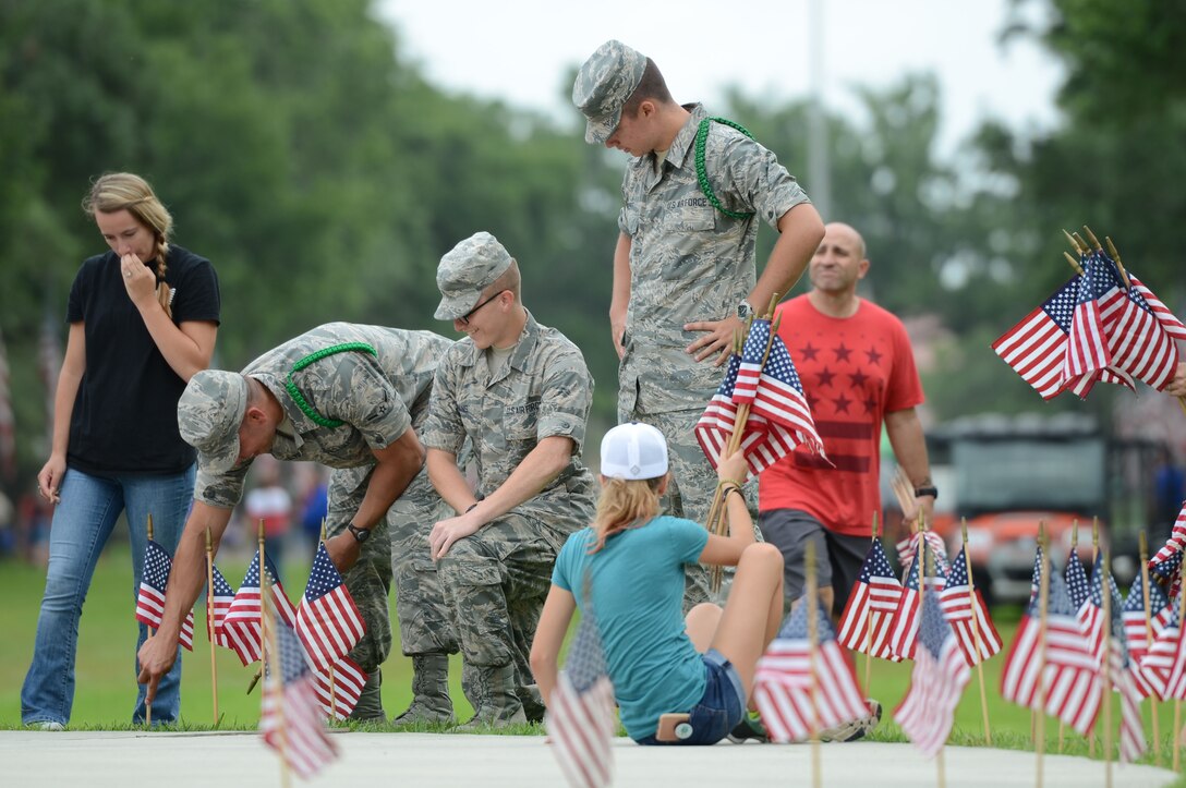 Keesler Airmen place U.S. flags on grave sites at Biloxi National Cemetery in recognition of Memorial Day, May 27, 2017, in Biloxi, Miss. Local veterans, family members and Keesler AFB personnel participated in the event to honor and remember the lives of fallen heroes of the U.S. military. (U.S. Air Force photo by Andrew Whitman)