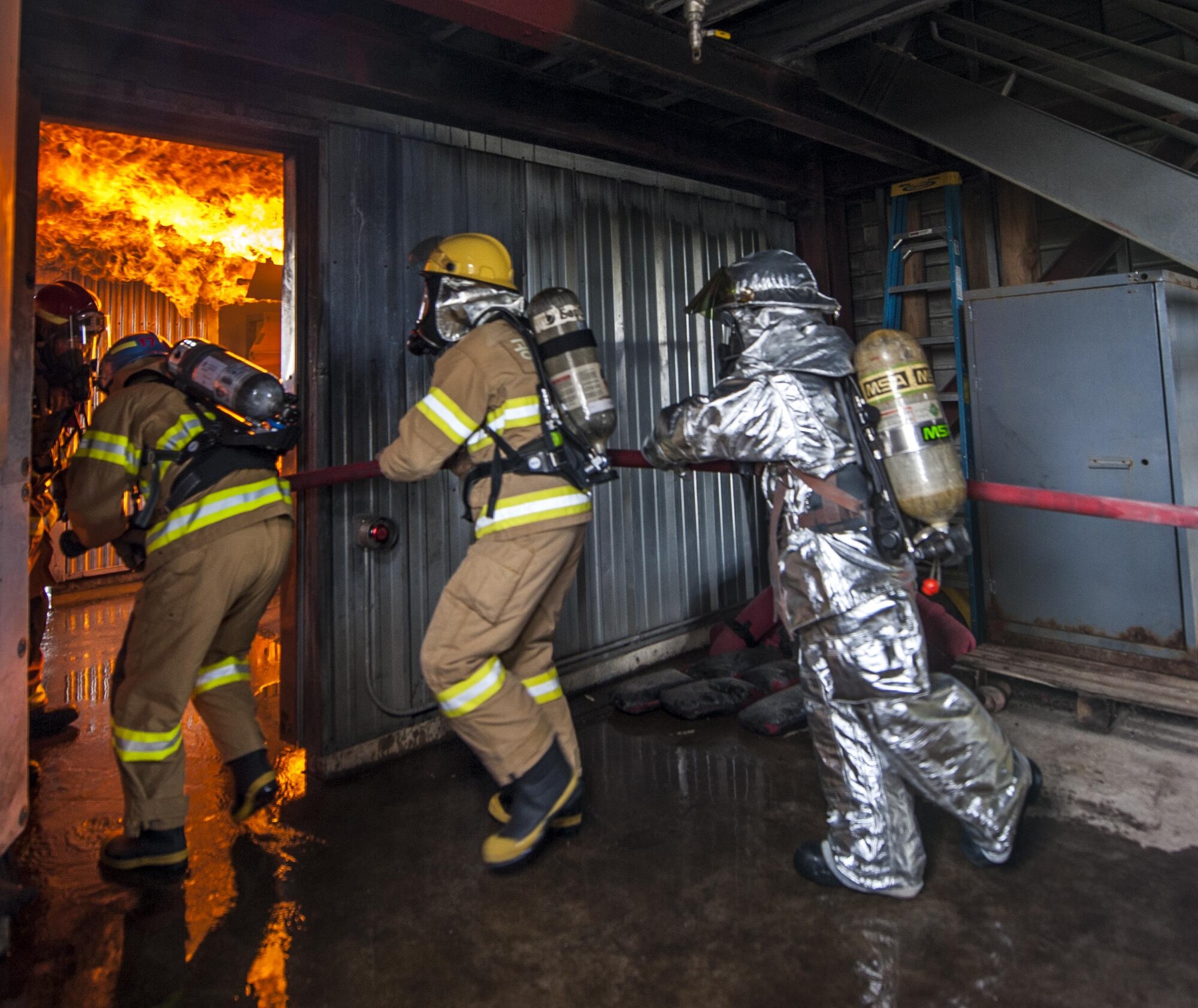 U.S. Air Force firefighters from the Kunsan Air Base 8th Civil Engineer Squadron, Osan Air Base 51st Civil Engineer Squadron, and Republic of Korea Air Force firefighters enter the live fire room during combined training exercise at Kunsan Air Base, Republic of Korea, May 23, 2017. The firefighters, who were broken up into small teams, were able to test their ability to extinguish structural fires during the training. (U.S. Air Force photo by Senior Airman Colville McFee/Released)