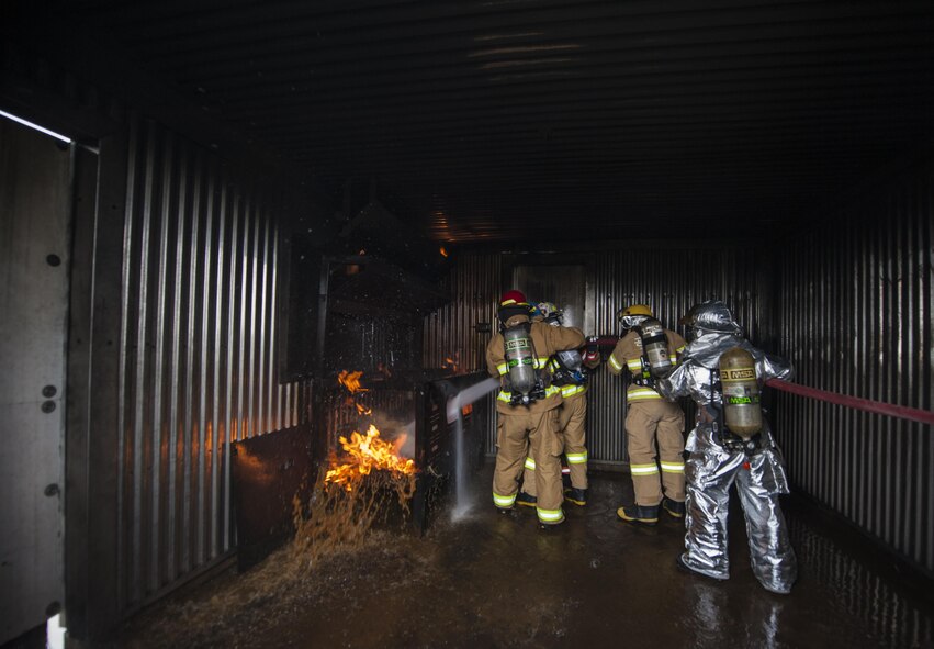 U.S. Air Force firefighters from the Kunsan Air Base 8th Civil Engineer Squadron, Osan Air Base 51st Civil Engineer Squadron, and Republic of Korea Air Force firefighters spray a fire with water during combined live fire training at Kunsan Air Base, Republic of Korea, May 23, 2017. The training took place in specialized a building, which has the ability to generate a fire in its back room. (U.S. Air Force photo by Senior Airman Colville McFee/Released)