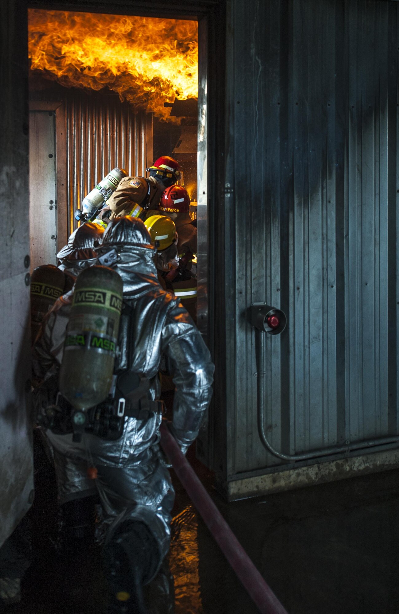 U.S. Air Force firefighters from the Kunsan Air Base 8th Civil Engineer Squadron, Osan Air Base 51st Civil Engineer Squadron, and Republic of Korea Air Force firefighters work together spraying  water toward a live fire during combined fire training at Kunsan Air Base, Republic of Korea, May 23, 2017. The firefighters, who were broken up into small teams, were able to test their ability to extinguish structural fires during the training. (U.S. Air Force photo by Senior Airman Colville McFee/Released)
