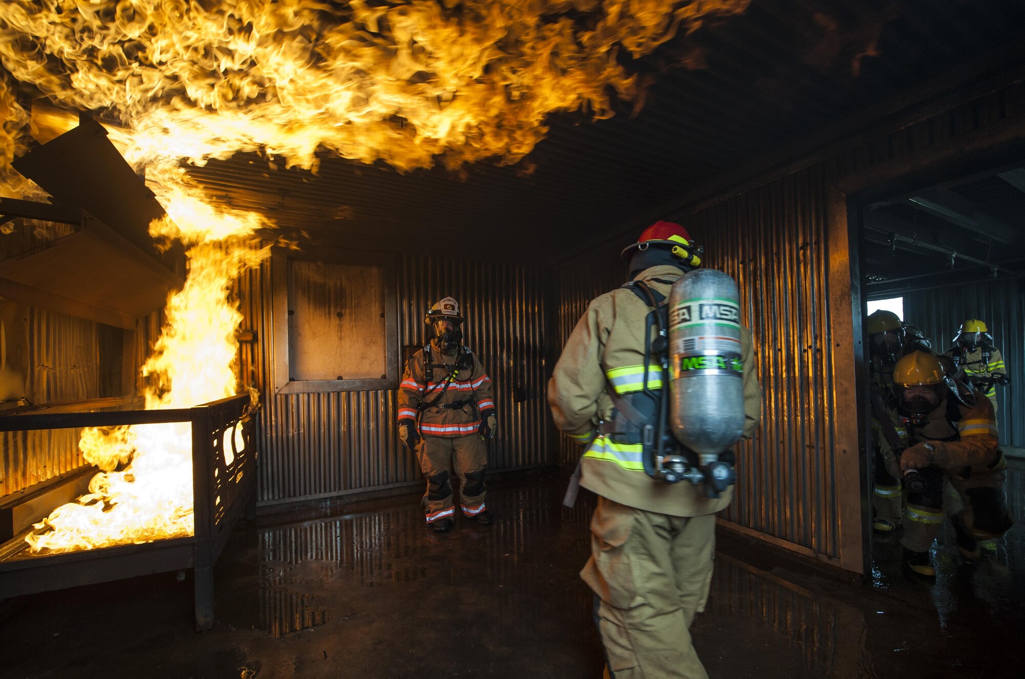 U.S. Air Force firefighters from the Kunsan Air Base 8th Civil Engineer Squadron, Osan Air Base 51st Civil Engineer Squadron, and Republic of Korea Air Force firefighters enter a live fire room during combined fire training at Kunsan Air Base, Republic of Korea, May 23, 2017. The firefighters, who were broken up into small teams, were able to test their ability to extinguish structural fires during the training. U.S. and ROKAF firefighters used the training to help bridge communication gaps and improve their efficiency in responding to real-world scenarios. (U.S. Air Force photo by Senior Airman Colville McFee/Released)