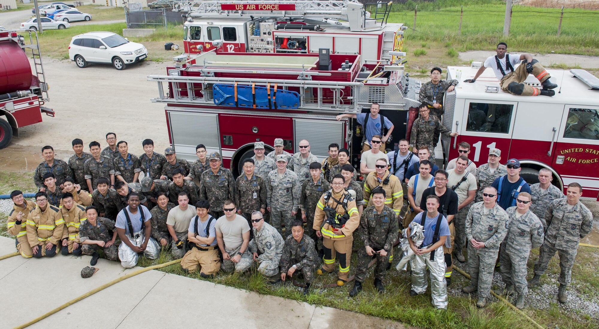 U.S. Air Force firefighters from the Kunsan Air Base 8th Civil Engineer Squadron, Osan Air Base 51st Civil Engineer Squadron, and Republic of Korea Air Force firefighters take a group photograph during a combined fire training on Kunsan Air Base, Republic of Korea, May 23, 2017. U.S. and ROKAF firefighters spent the day training together to help bridge communication gaps and improve their efficiency in responding to real-world scenarios. (U.S. Air Force photo by Senior Airman Colville McFee/Released)