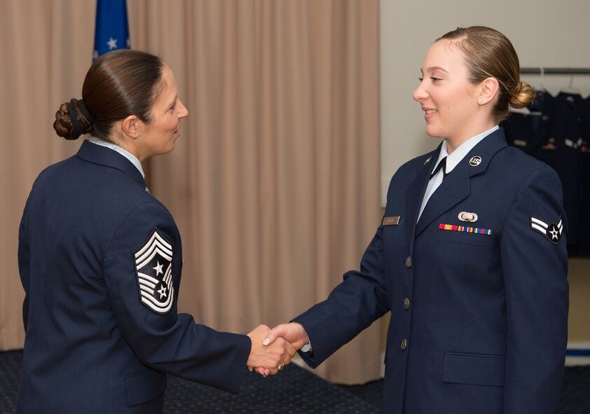 Hanscom Command Chief Master Sgt. Patricia L. Hickey congratulates Airman 1st Class Emma Field on her promotion to E-3 during an enlisted promotion ceremony at the Minuteman Commons May 31. Field, a member of the C3I and Networks Directorate, was among several promoted during the monthly ceremony, typically held the last day of the month. (U.S. Air Force photo by Jerry Saslav)