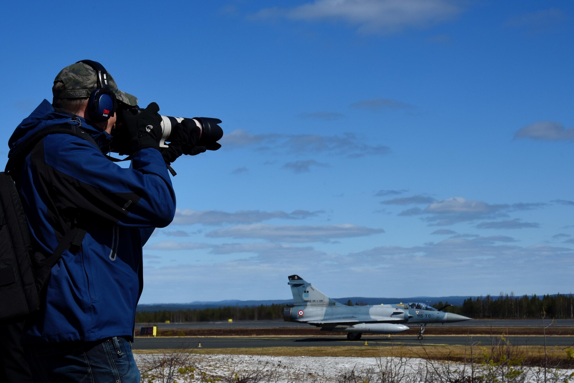A media representative takes photos of a French Mirage 2000 during the Arctic Challenge 2017 media day at Rovaniemi Air Base, Finland, May 23. Media representatives from multiple nations gathered to learn about the exercise, which is aimed at developing a strong relationship between participating militaries. (U.S. Air Force photo/Airman 1st Class Abby L. Finkel)
