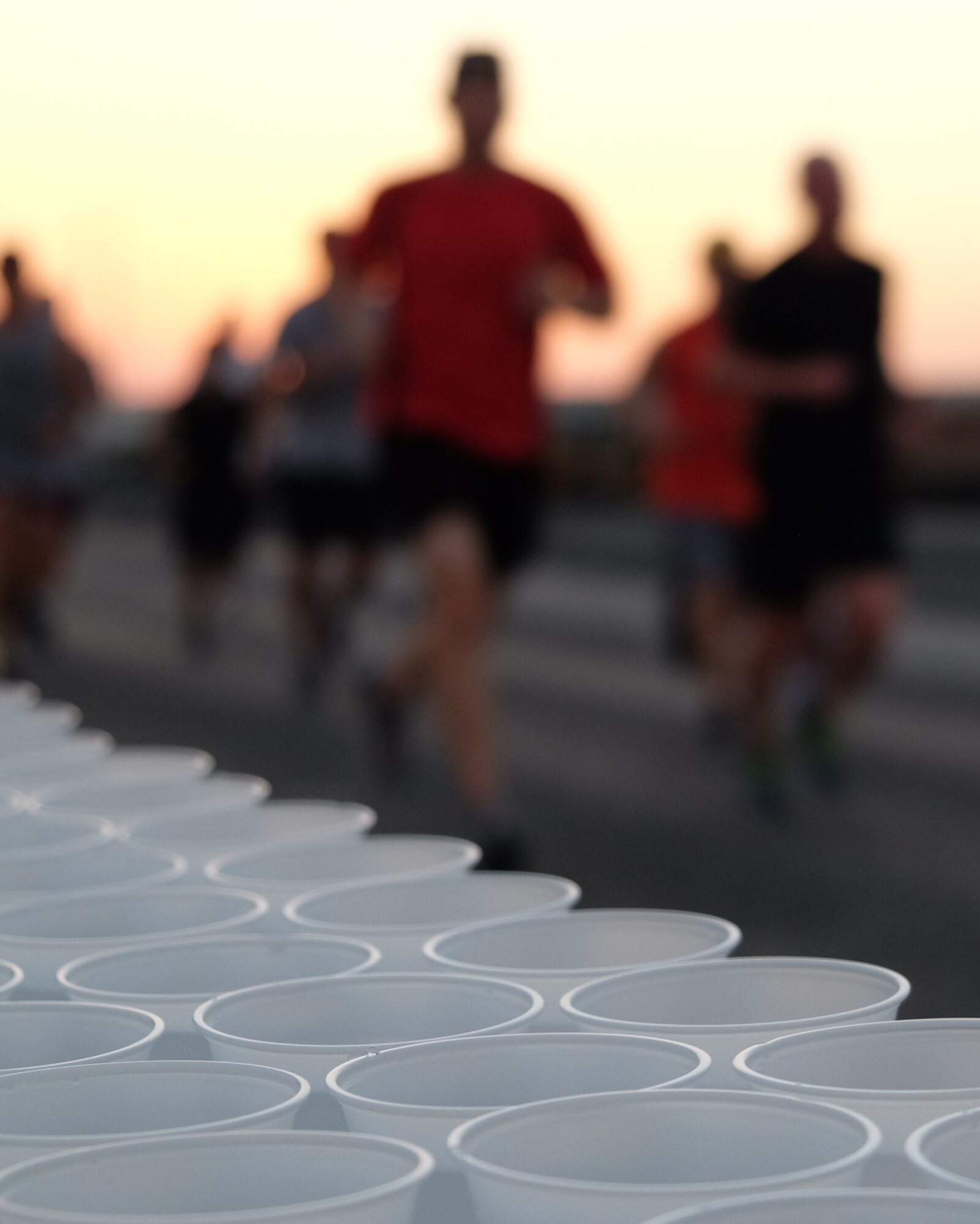 Airmen with 380th Air Expeditionary Wing and Coalition Partners jog passed a water station during a Memorial Day 5-km run May 29, 2017, at an undisclosed location in southwest Asia. The run served as an opportunity for all service members on base to join together and remember their fallen comrades. (U.S. Air Force photo by Senior Airman Preston Webb)