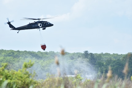 New York Army National Guard aircrew from the 3rd Battalion, 142nd Aviation prepare to fill a Bambi Bucket with water from Round Lake, N.Y., May 31, 2017. The aviators were conducting a slow pick-up in order to fill their bucket with as much water as possible, which they would next practice dumping out. 