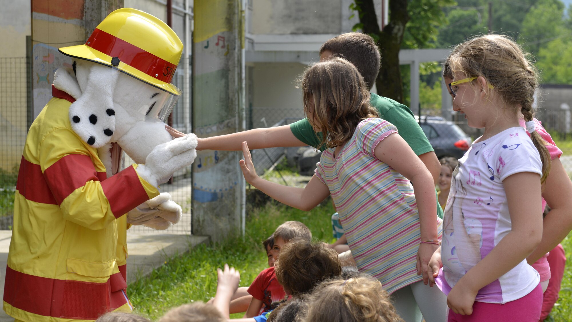 Sparky the fire dog meets Italian children during a visit by the 31st Civil Engineer Squadron, May 31, 2017 in Polcinego, Italy. Members of the 31st Civil Engineer Squadron Fire Department visited the school to show the children firefighting equipment and teach fire safety. (U.S. Air Force photo by Senior Airman Cary Smith)